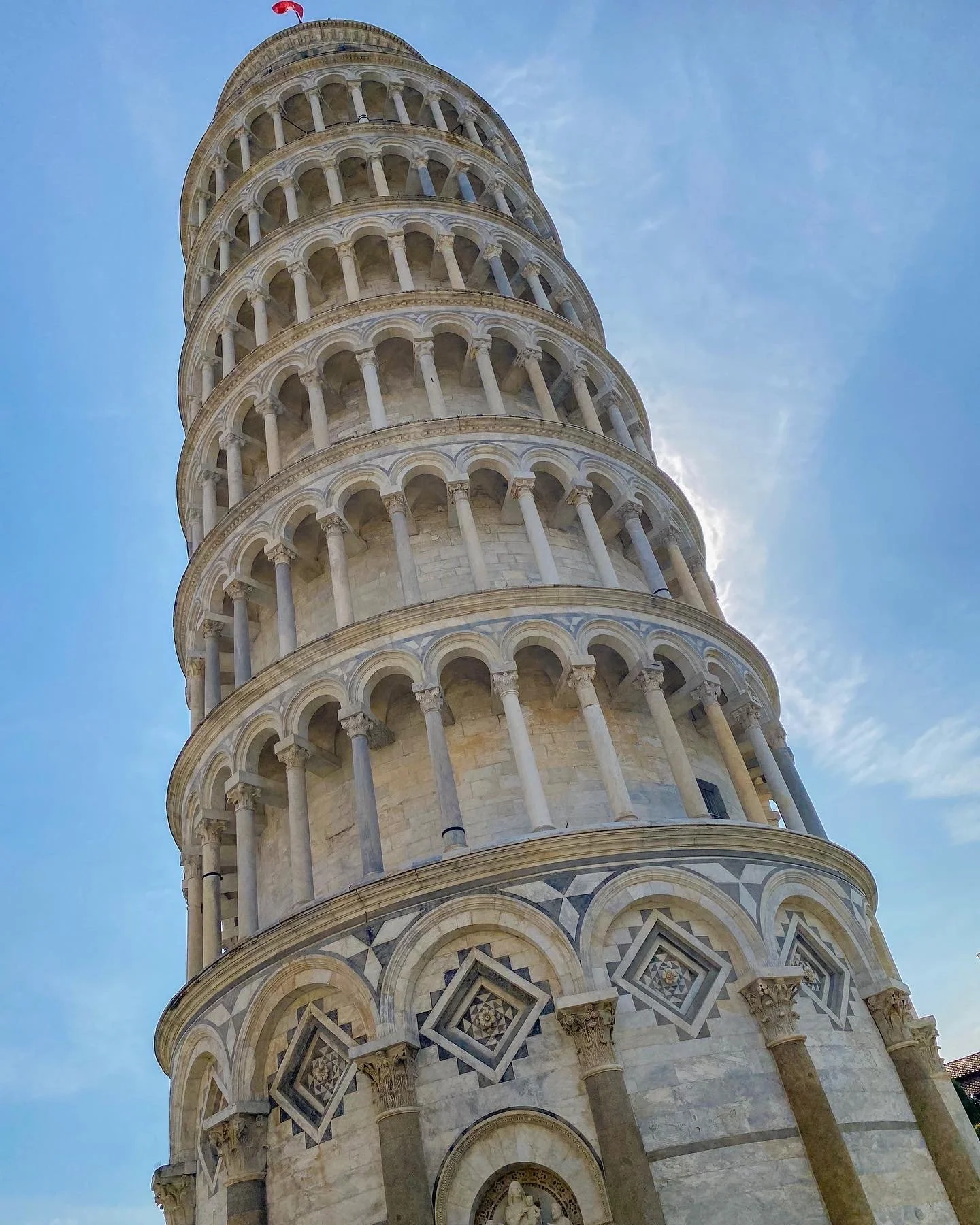 The Leaning Tower of Pisa against a blue sky.