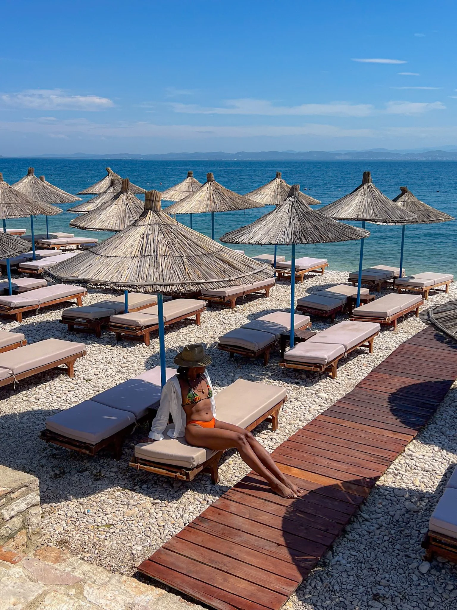 Thatched umbrellas and sun loungers lined up along the beach, Vlore, Albania