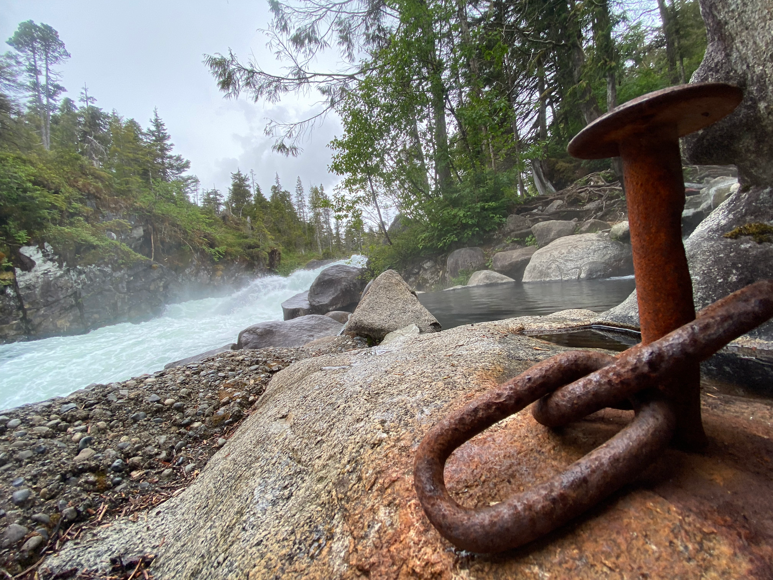 Old rusted spike in front river rapids