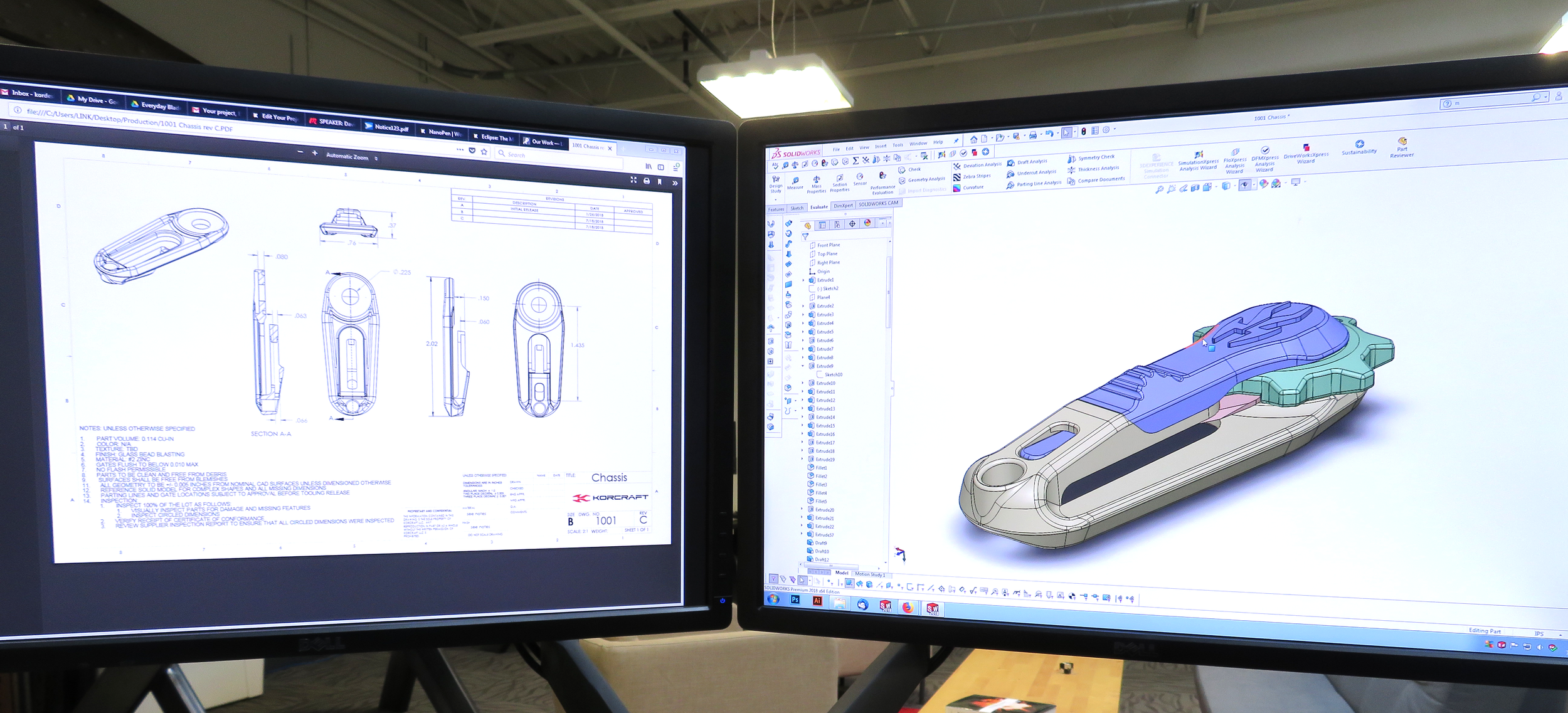 Two computer monitors displaying a technical design and 3D model of a device, with engineering drawings on the left screen and a colored 3D CAD model on the right screen.