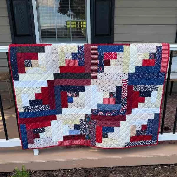 Scrappy red, white, and blue log cabin quilt