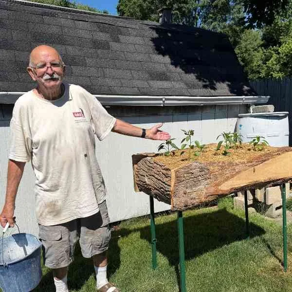 Kris's dad with a wooden raised garden bed that he made.