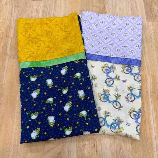 Two pillowcases; one with frogs and one with bicycles