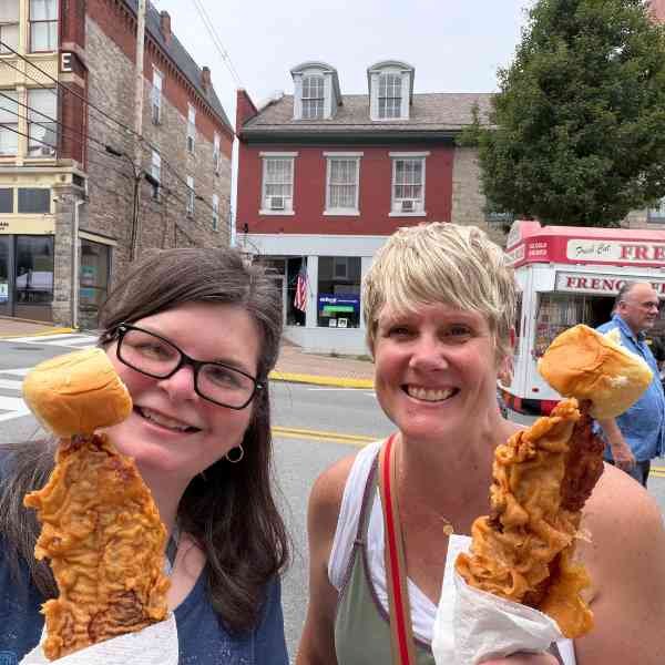 Kris and a friend with chicken on a stick