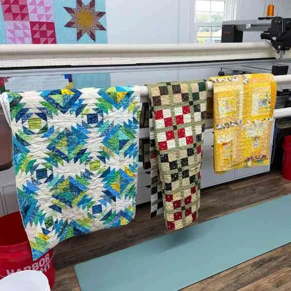 Quilts hanging on a long arm