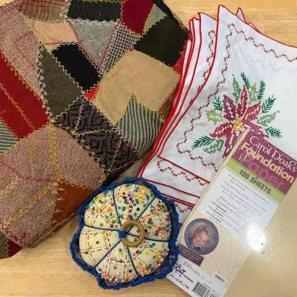 Yard sale finds including quilt, pin cushion, and placemats 