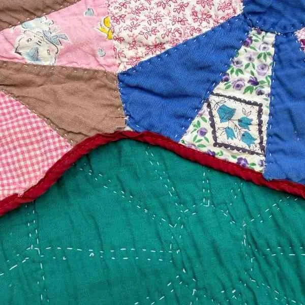 Shows the continue of the quilt with some holes and wear.