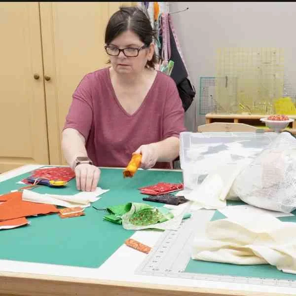 Kris at the cutting table cleaning up