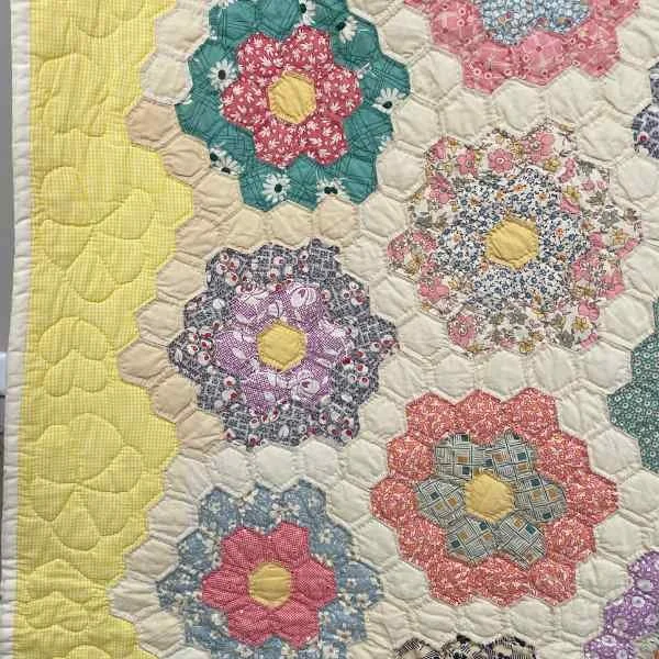 Quilting in the border of Antique Grandmothers Flower Garden Quilt