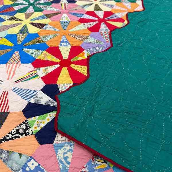 The zig zag binding is flipped onto the top of the quilt so you can see the backing, binding, and the front.
