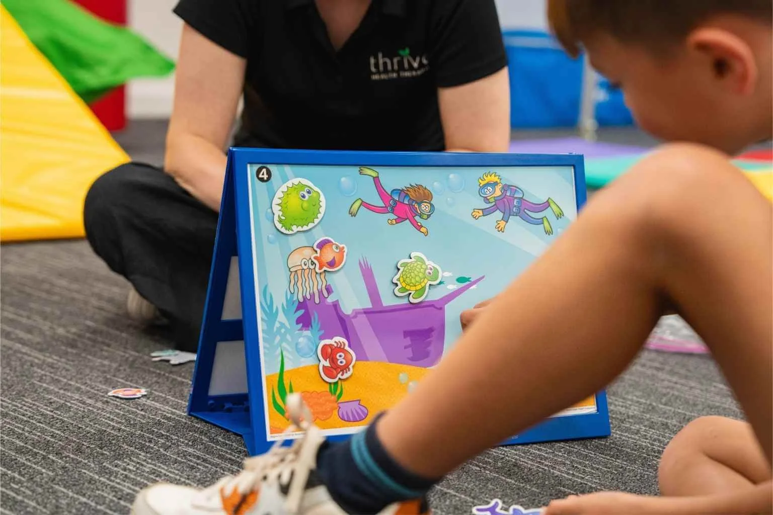 Speech therapist and child using a language therapy tool at Findon clinic