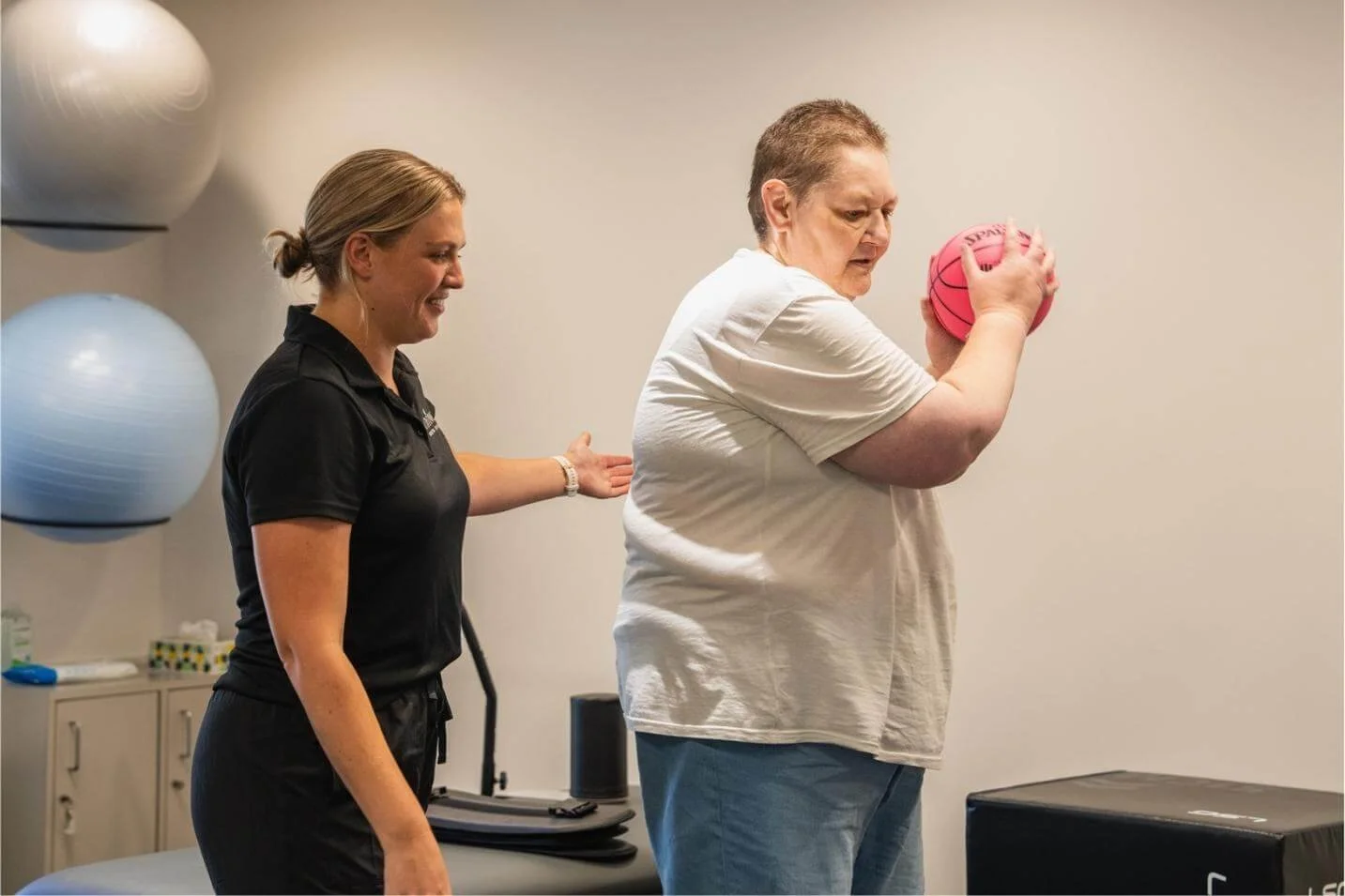 Exercise physiologist working with client who is throwing a ball