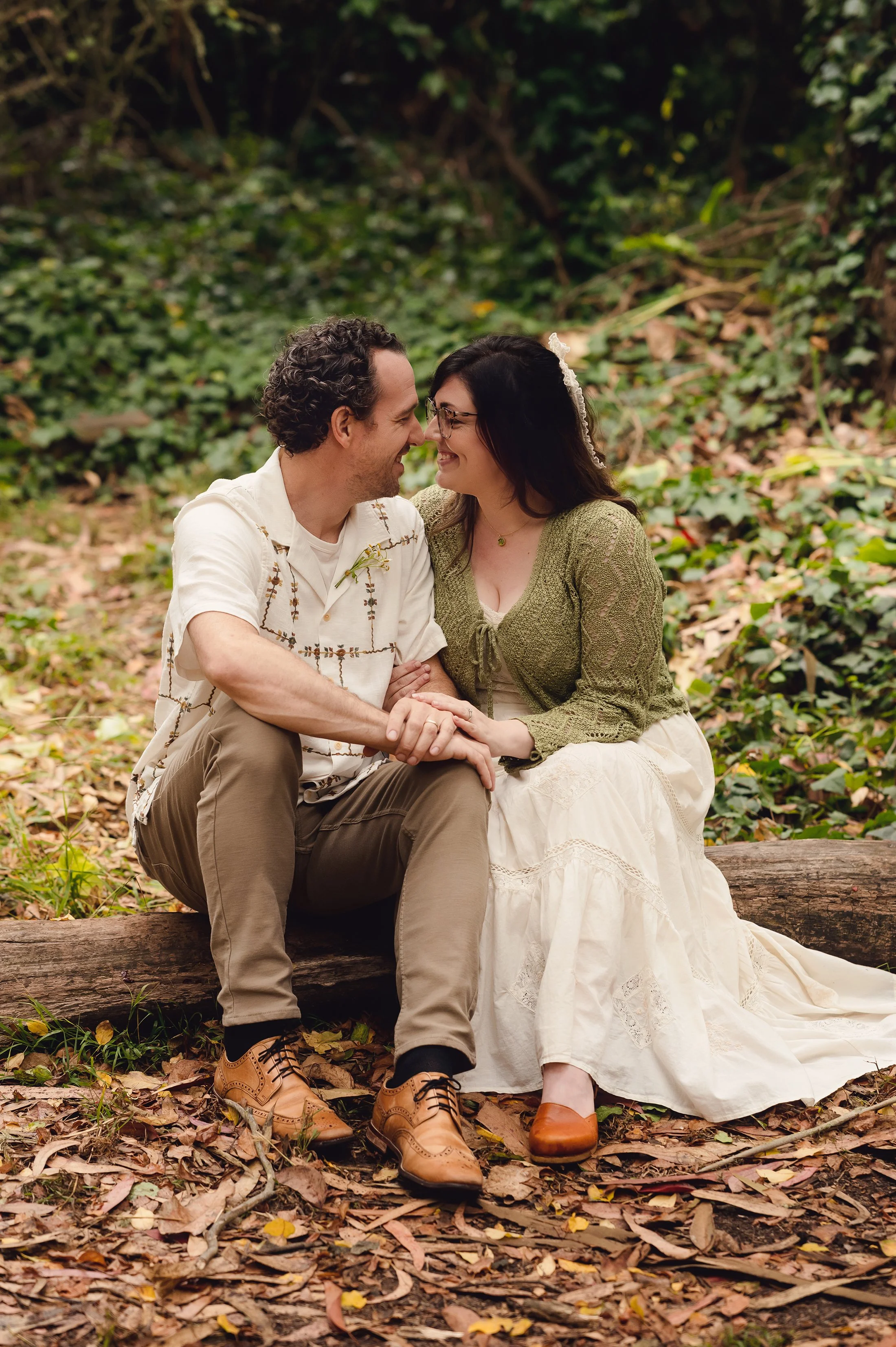 a couple sits on a log in Goldgen Gate park