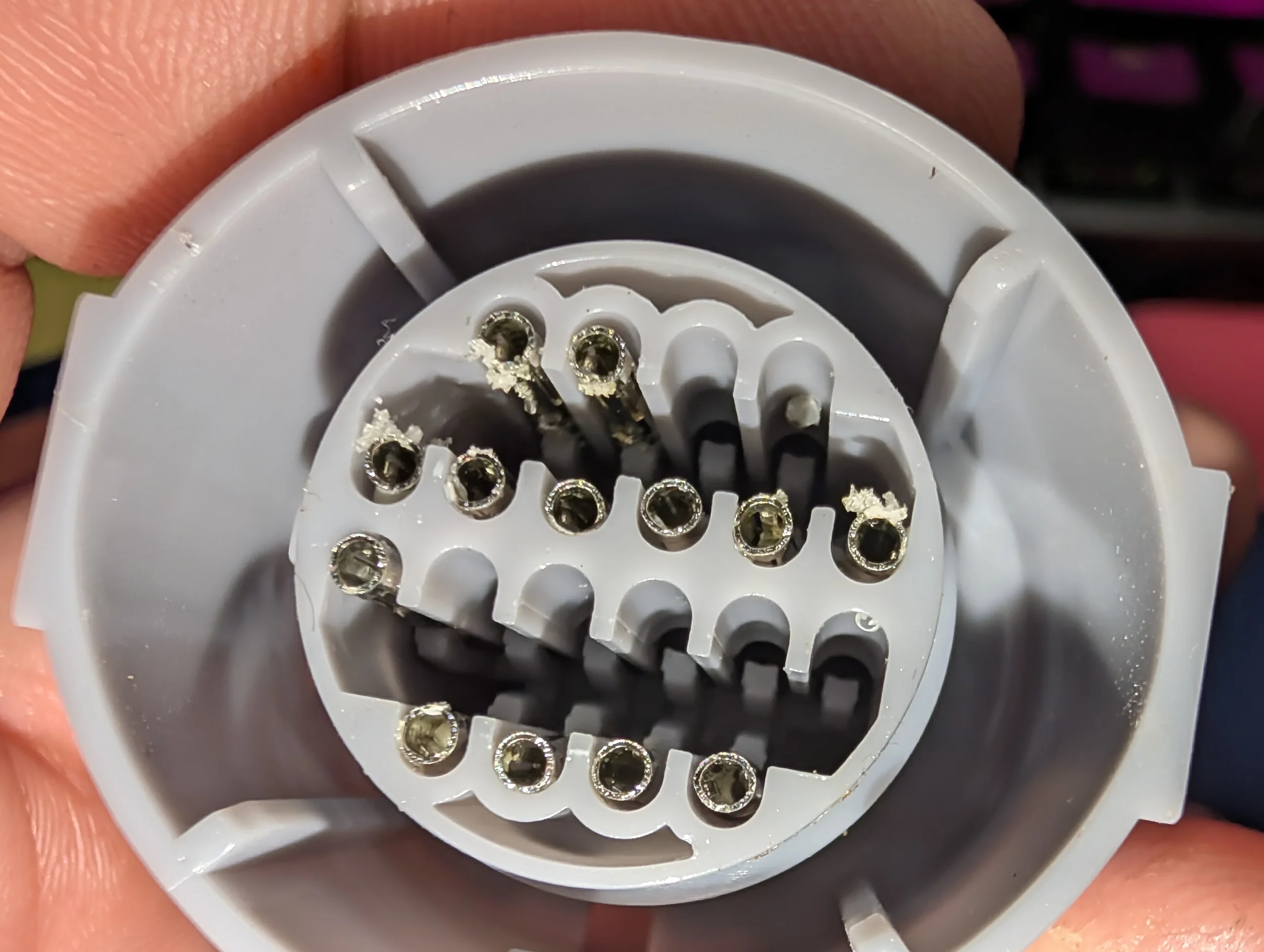 Exposed female terminals inside a GM 4L60E transmission plug with the retainer removed, ready for repinning cavities S, T, and U for 4L80E compatibility.