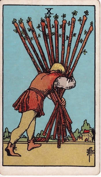 Ten of Wands tarot card showing a figure hunched under the weight of ten bundled wands, struggling toward a distant town