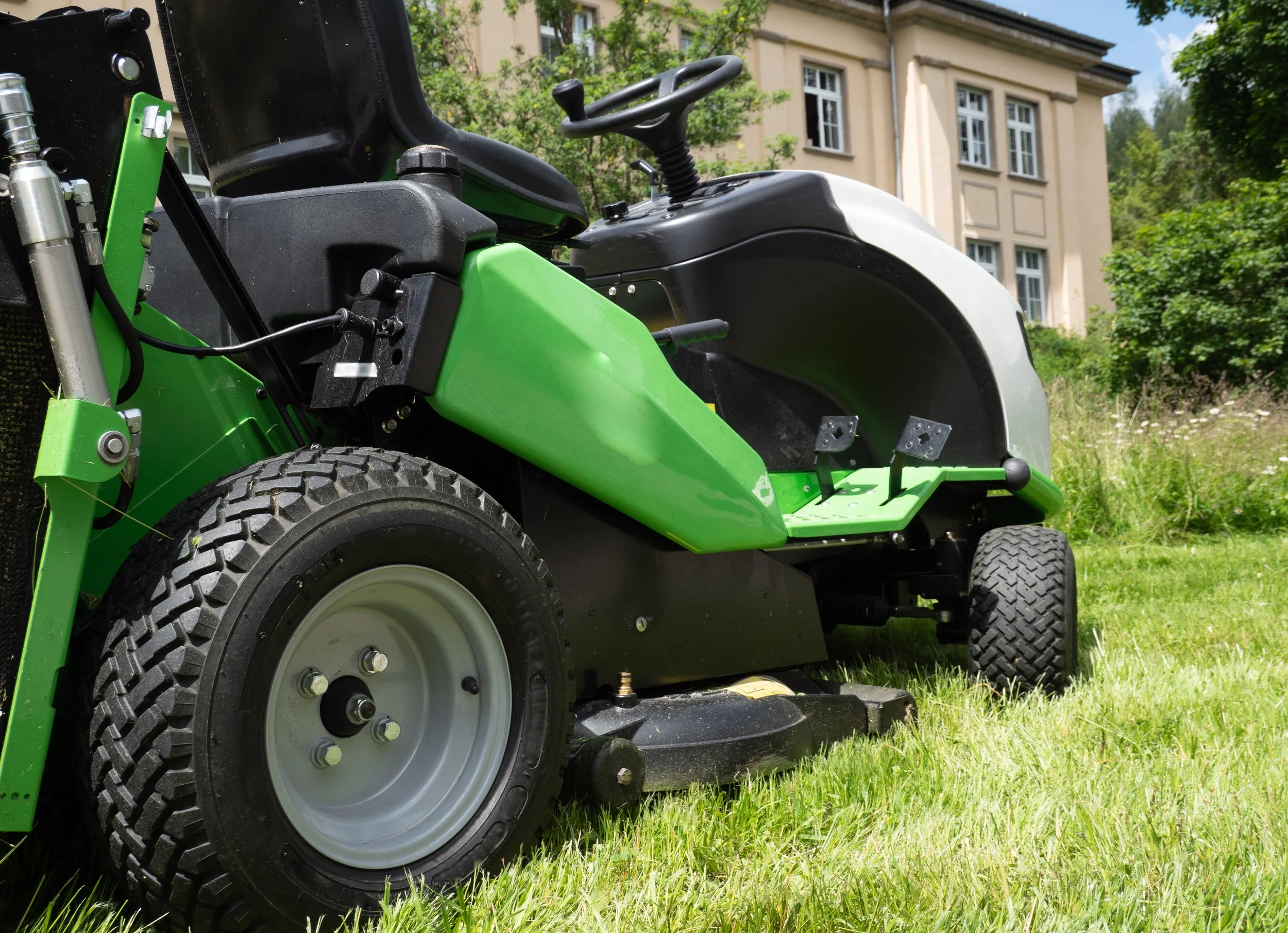 Commercial ride-on mower cutting grass at a large property in Gloucestershire.
