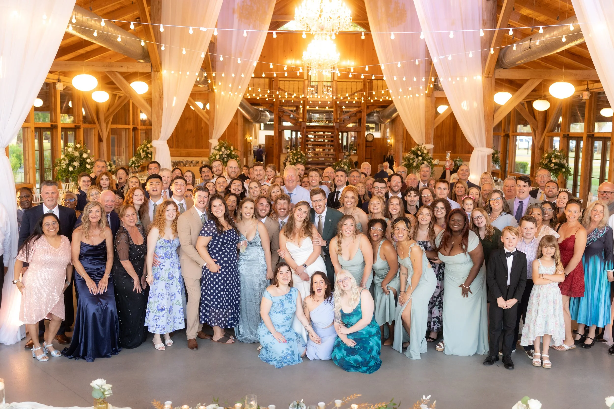 Bride and groom celebrate with family and friends during a large group wedding portrait inside Cottonwood Ranch in Callahan, Florida.