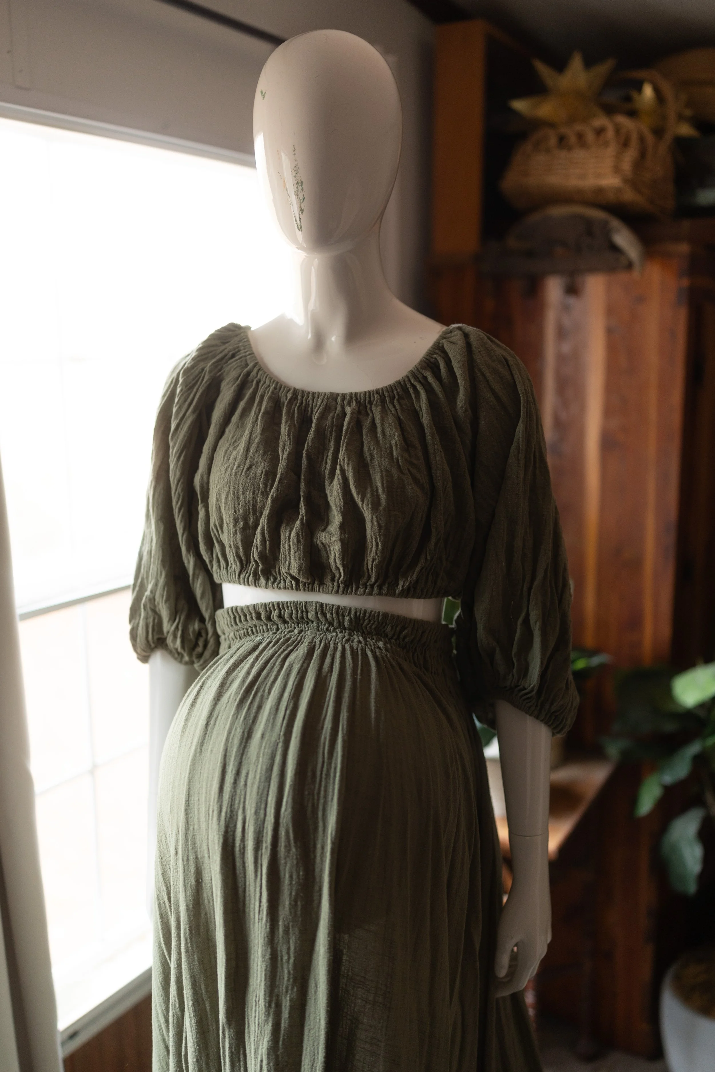 Earthy olive maternity set worn above the bump, with soft puff sleeves and textured, flowy fabric.
