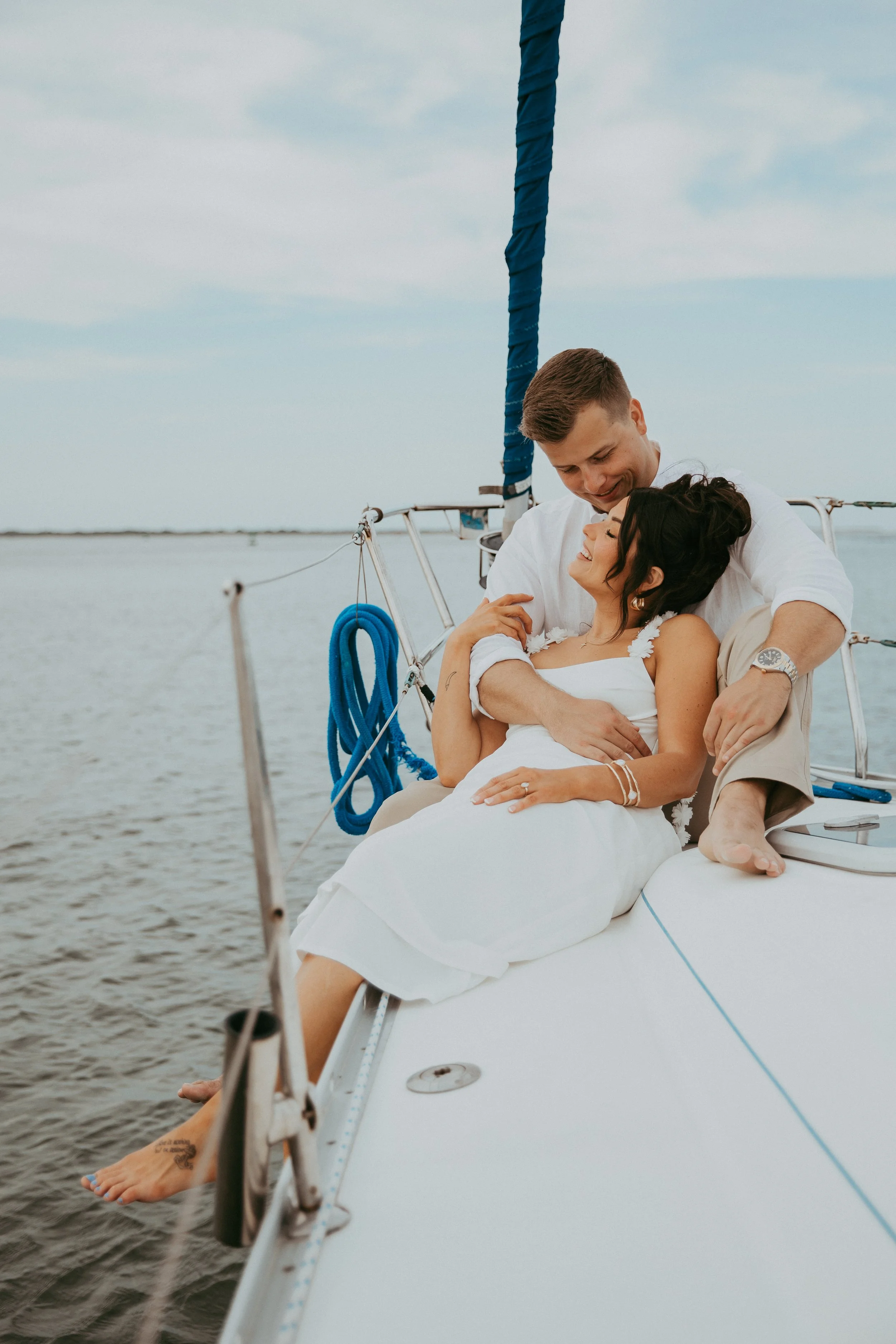 Lyndsey and Adam cuddle beside the water during their Fernandina Beach engagement session