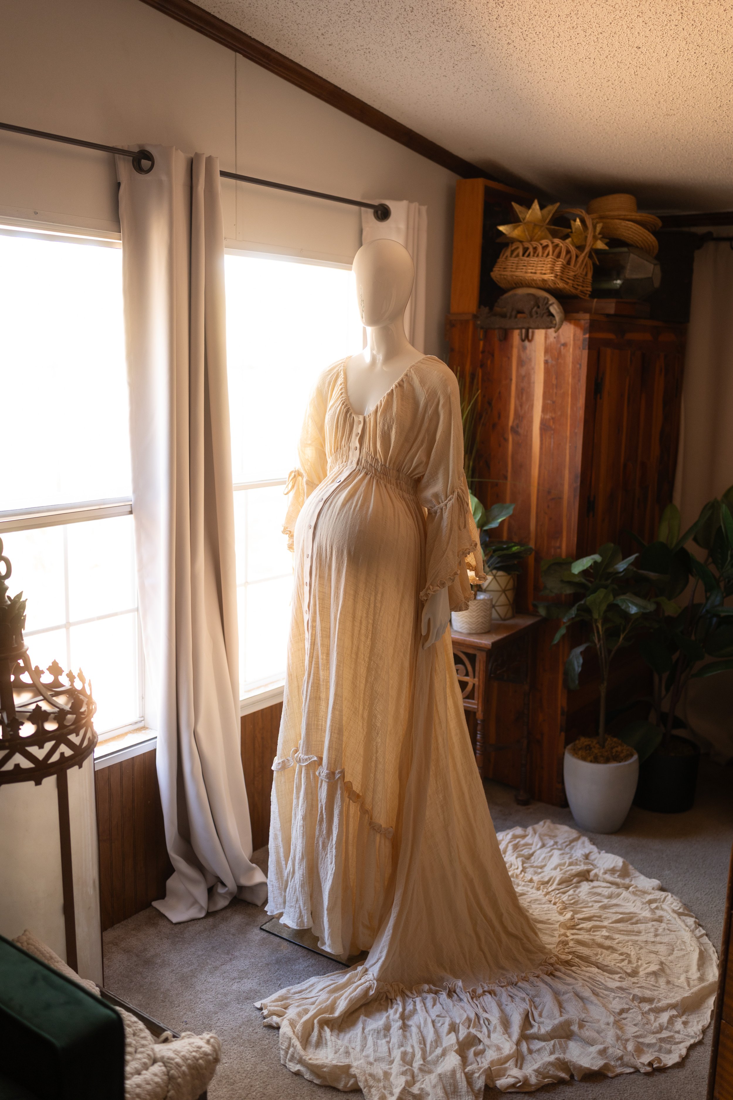 Whimsical long-sleeve gown styled over the baby bump, featuring gentle gathers and an airy, effortless silhouette.