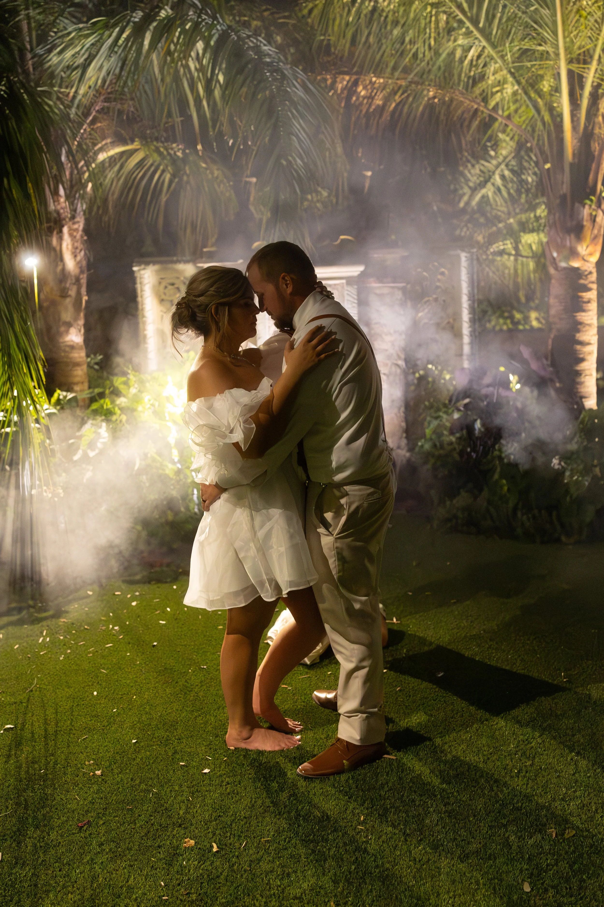 Moody nighttime wedding photo of bride and groom sharing a quiet dance.