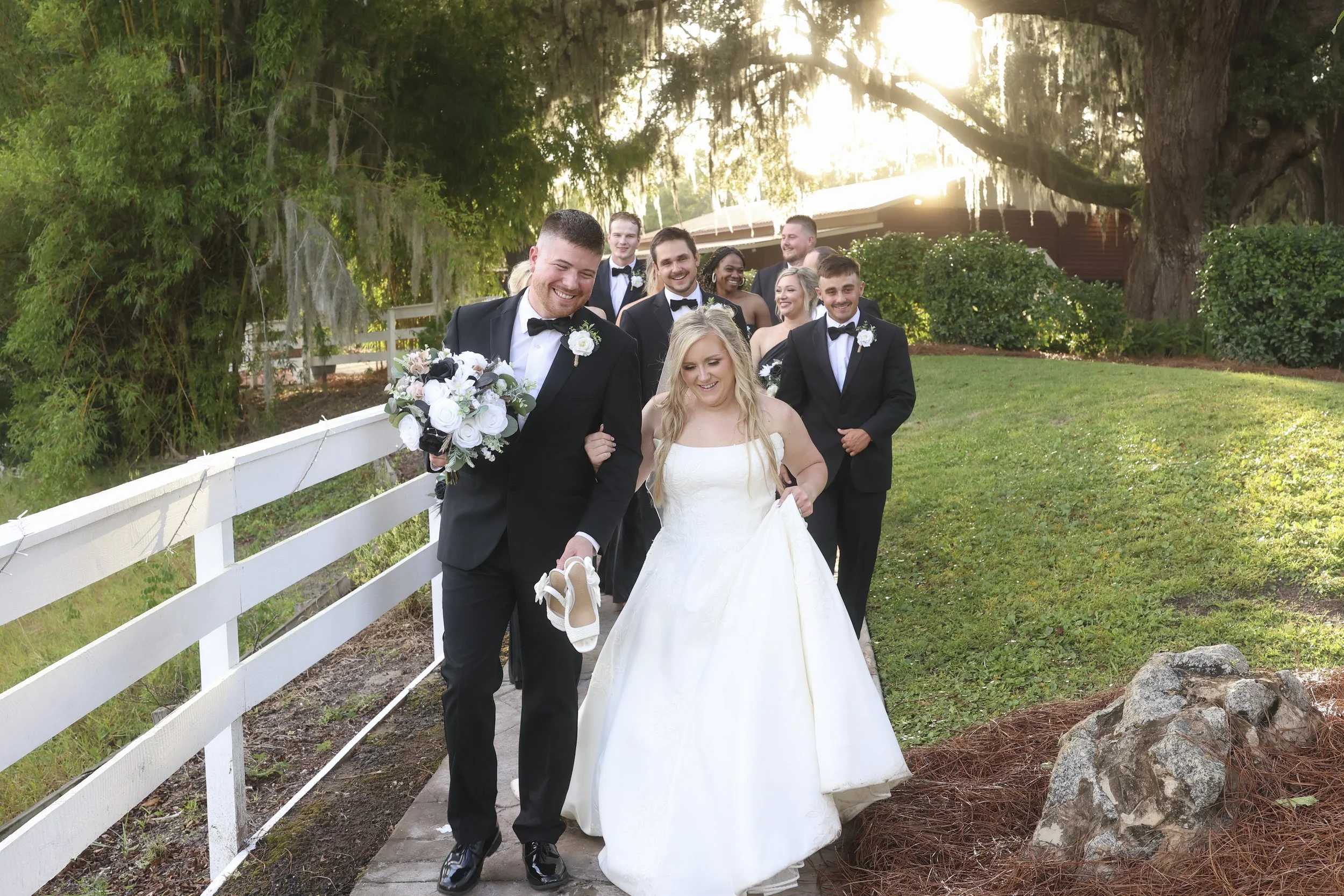 Hand in hand, they move forward laughing, carried by love, friends, and the happiness of the moment.