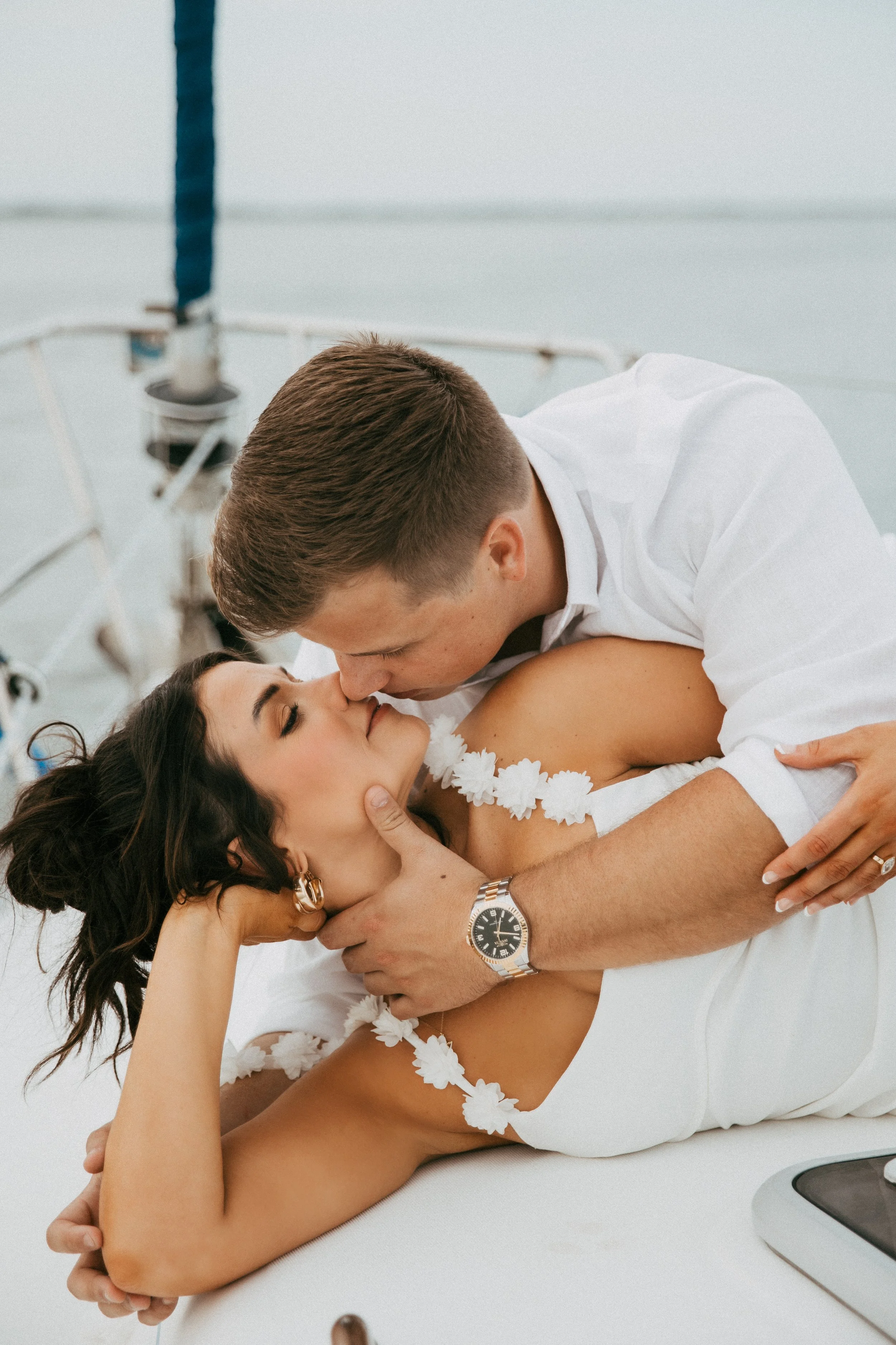 Close portrait of Lyndsey and Adam sharing a playful kiss on the bow