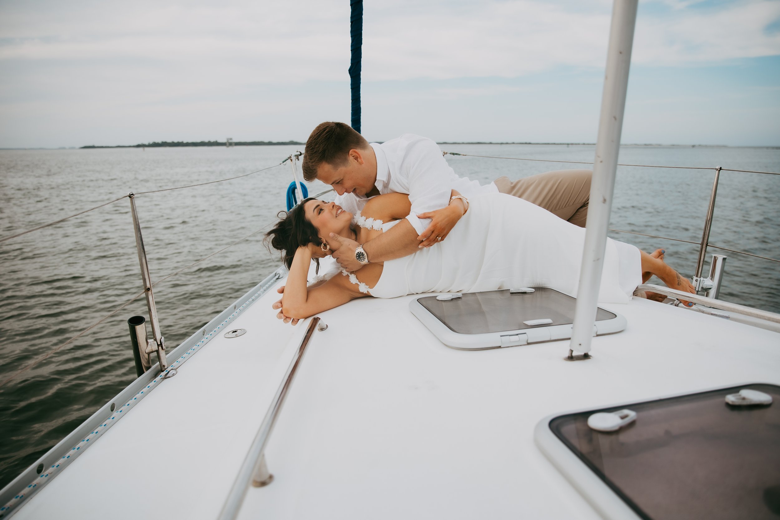 Lyndsey and Adam embrace beneath the sail during their Amelia Island engagement session