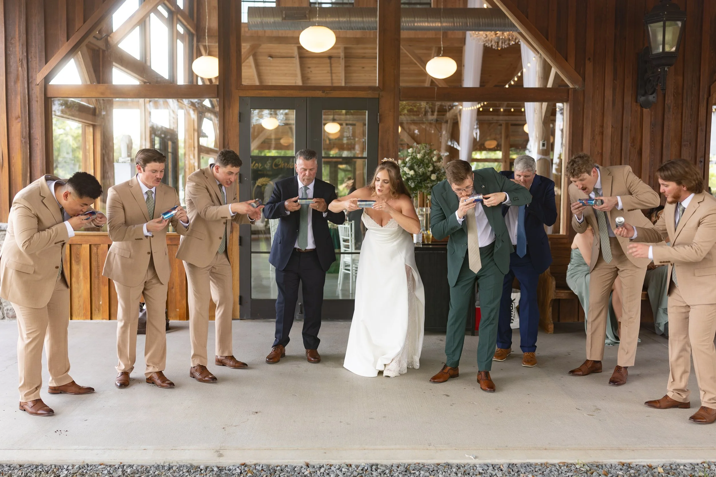 The bride and groom celebrate with their wedding party during a fun shotgun toast.