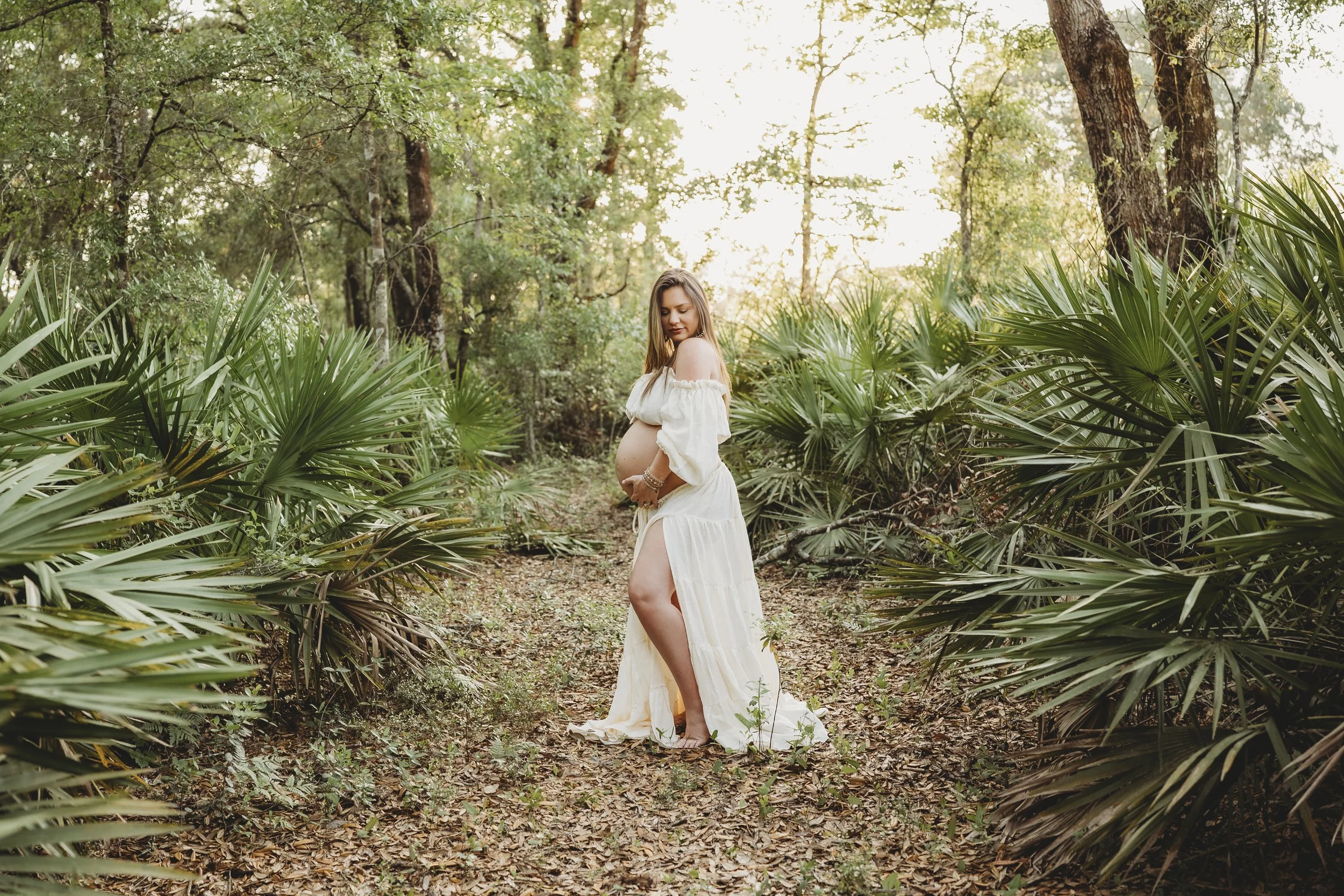 Light, airy maternity dress worn over the belly in a natural outdoor field setting, flowing softly with movement.