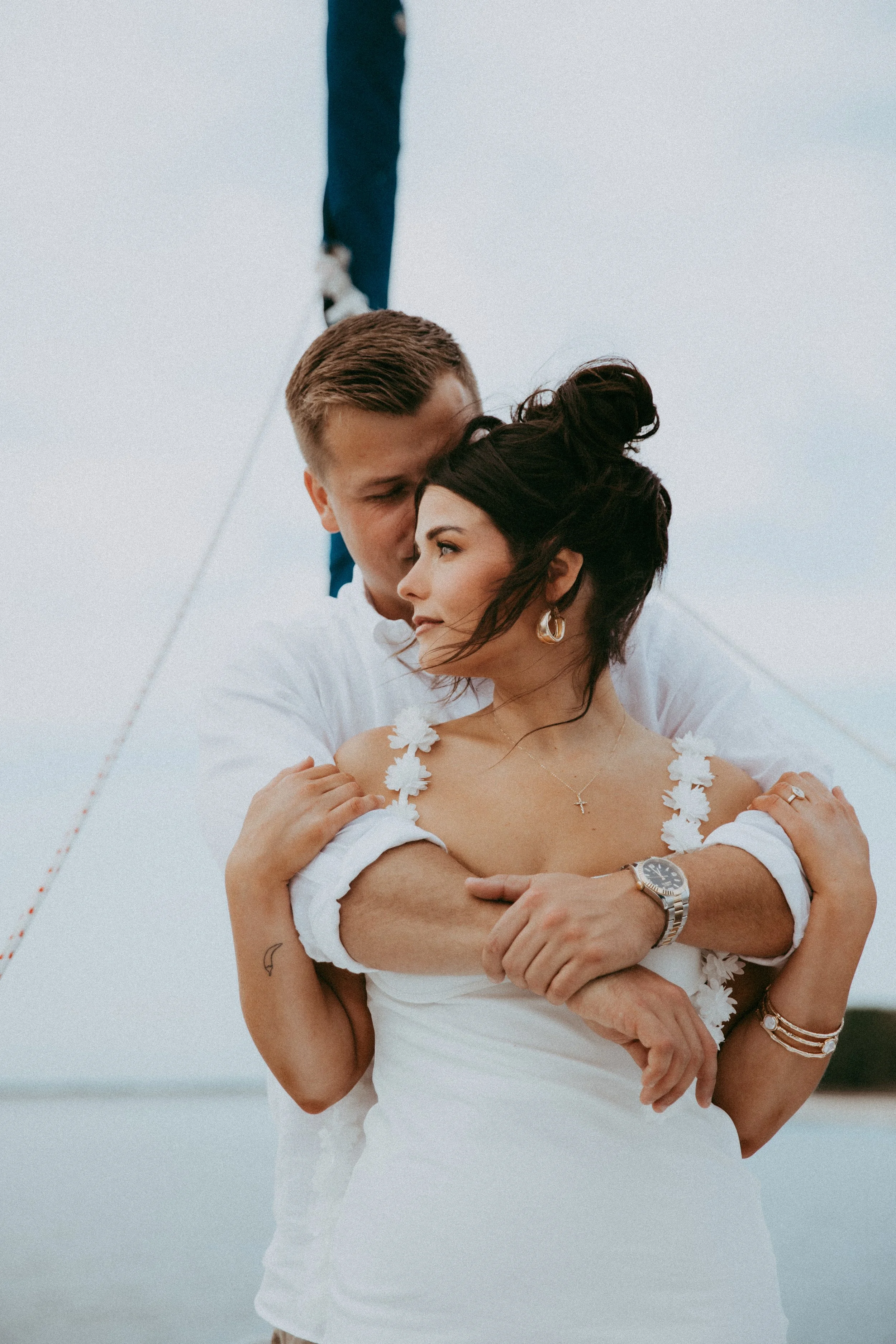 Adam wraps his arms around Lyndsey during their sailboat engagement session
