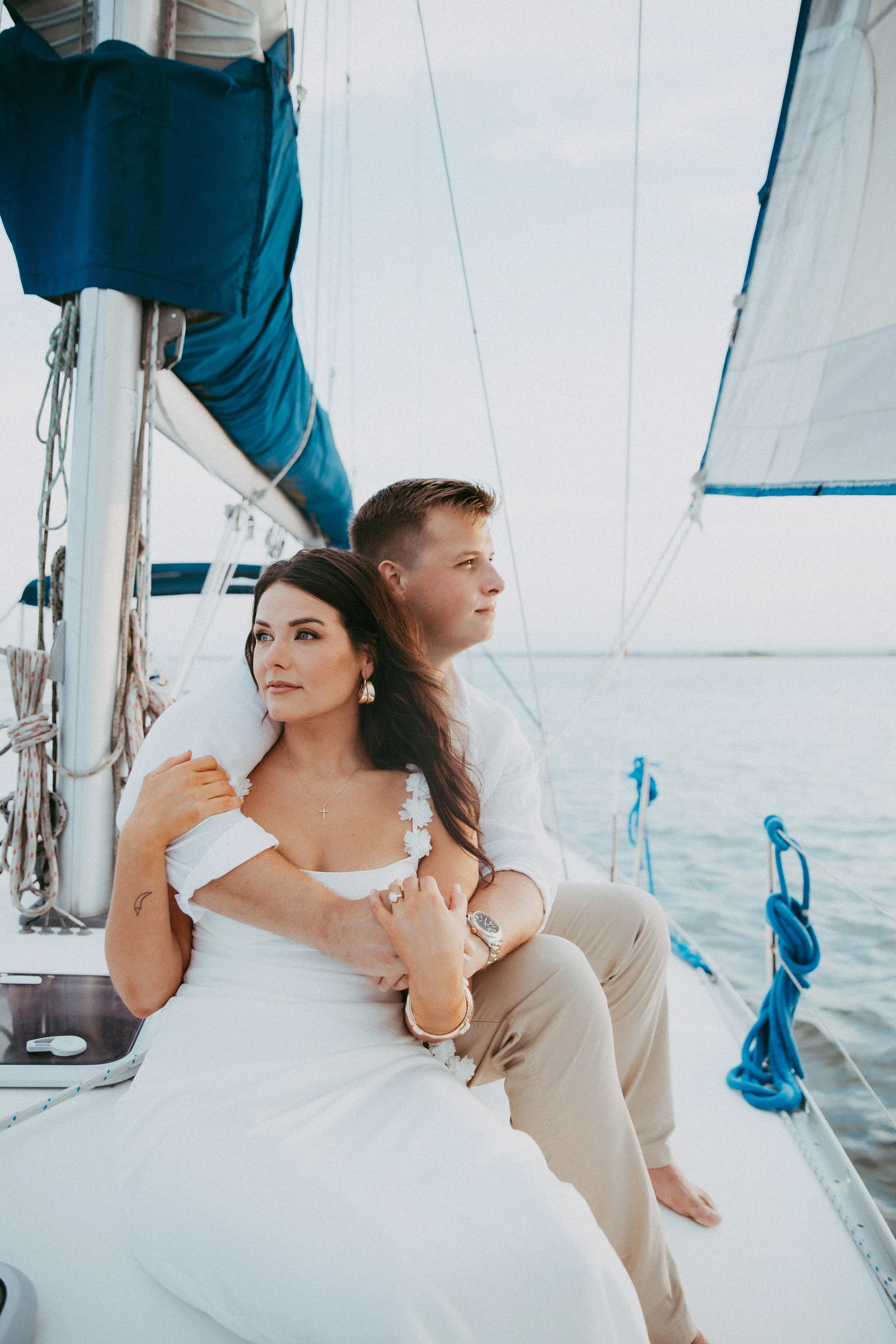 Lyndsey and Adam sit wrapped in each other’s arms near the end of their sailboat session
