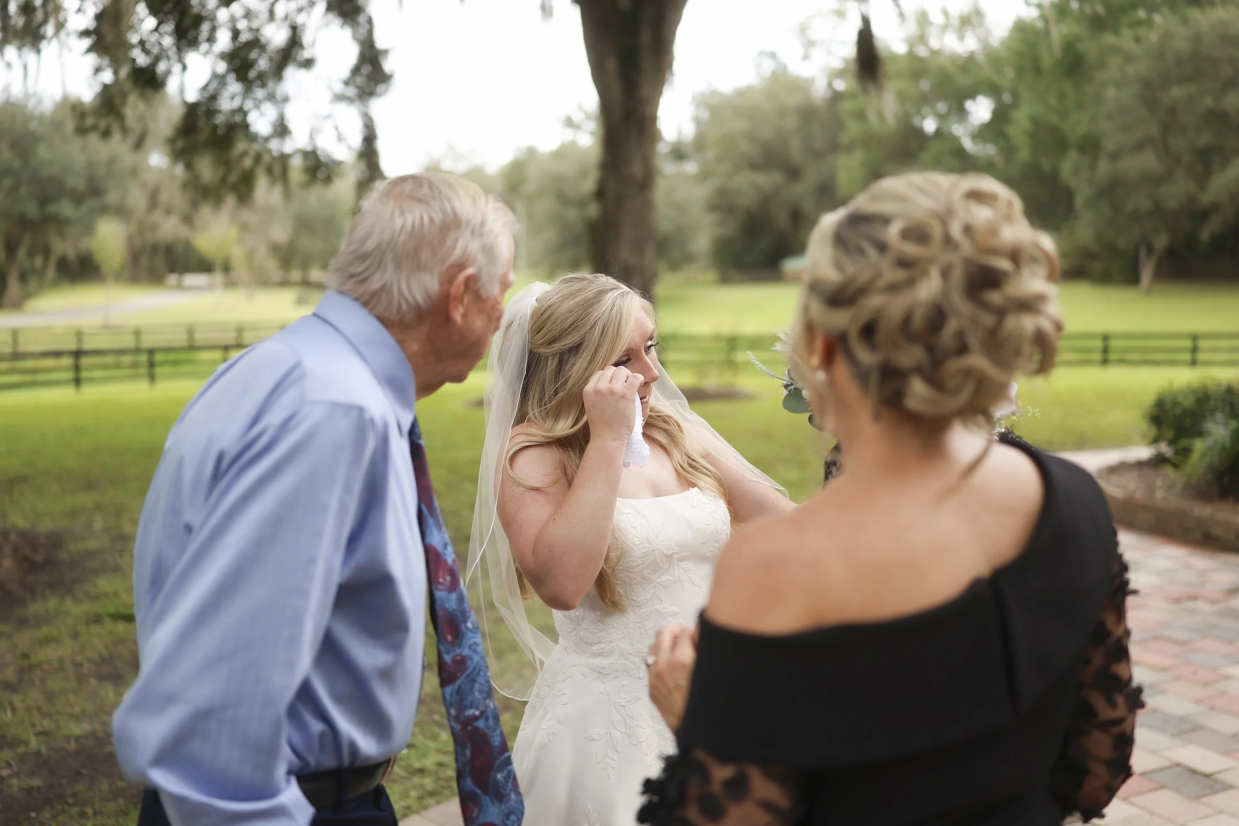 Just before walking forward, she leans into the comfort of family—tears, reassurance, and generations of love close by.