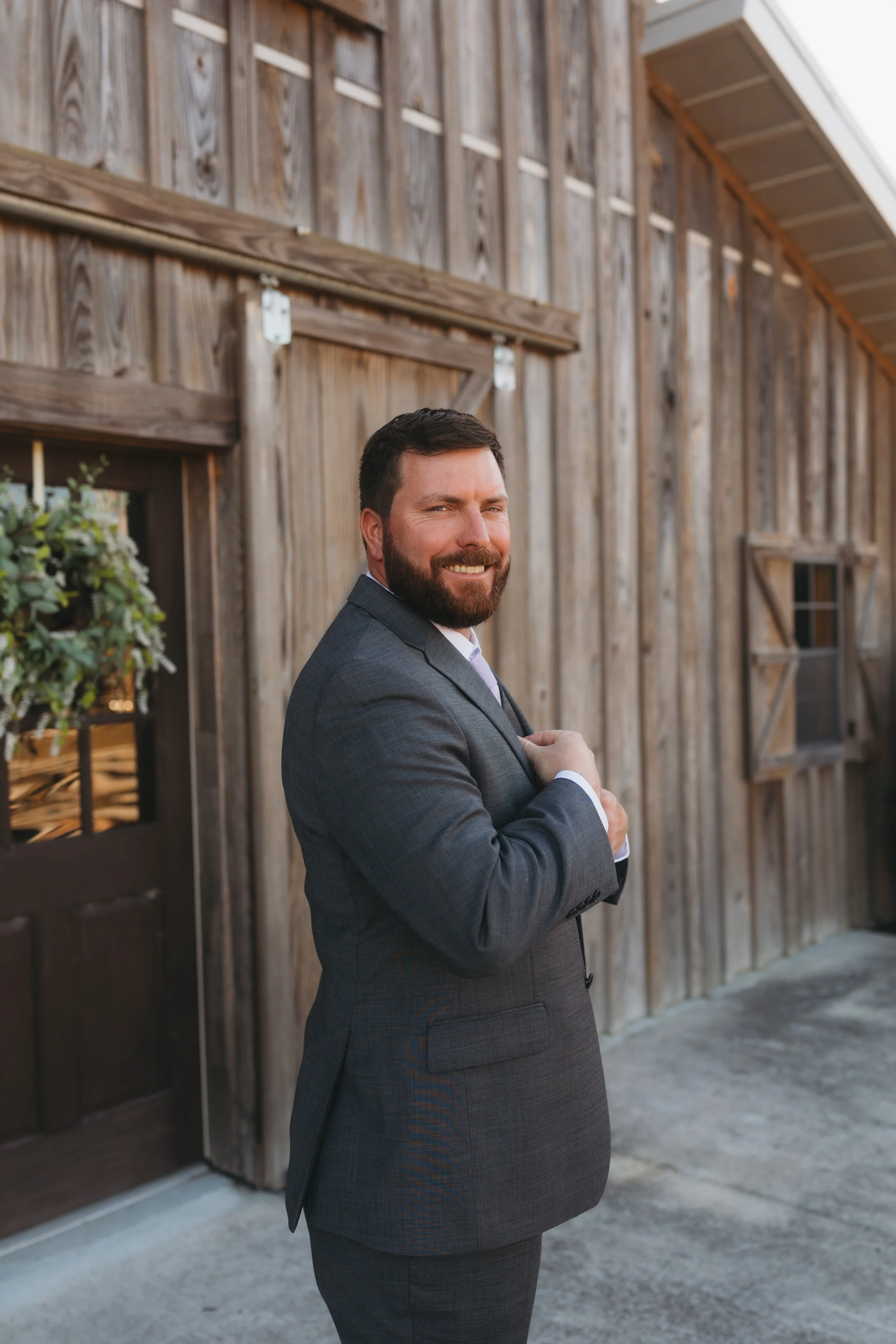 Groom standing outside the venue, smiling confidently as he prepares for the wedding ceremony
