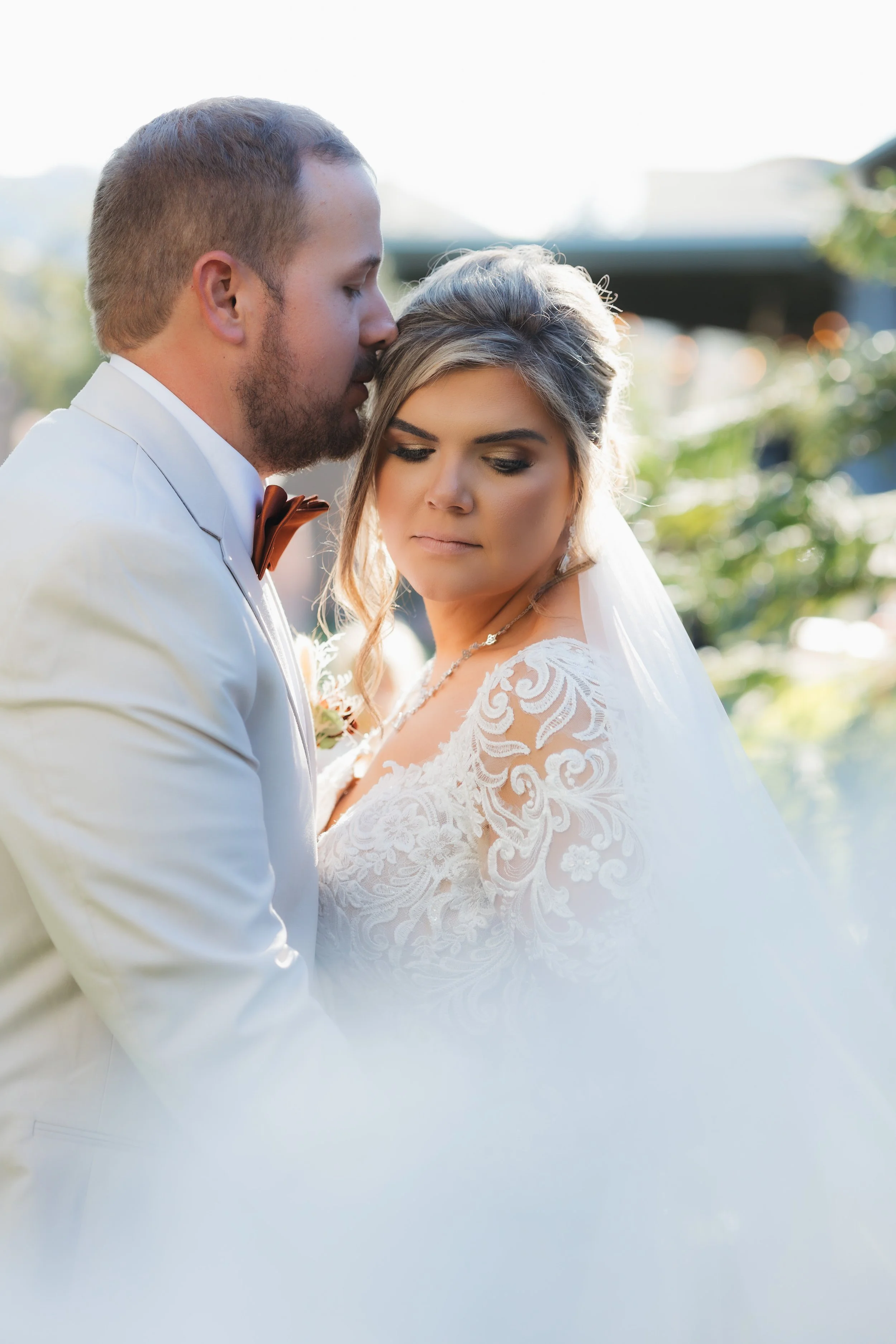 Groom leaning in close to the bride during an outdoor wedding portrait