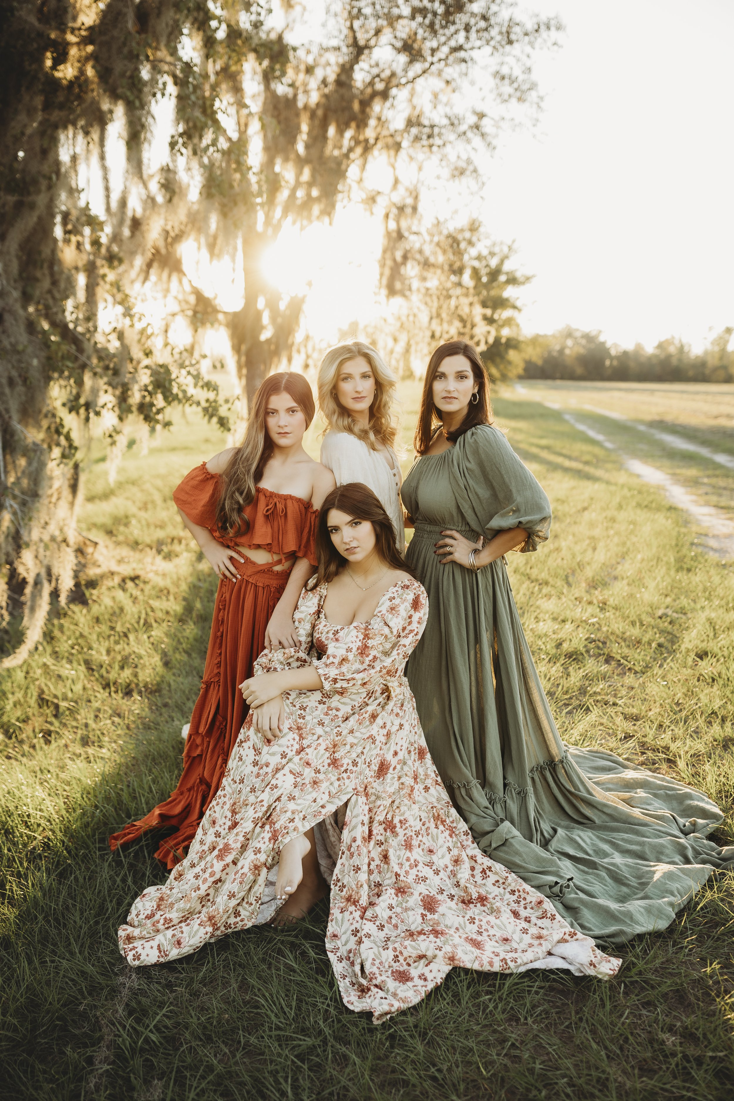 Boho-inspired maternity dresses styled above and below the belly, photographed on women in a glowing outdoor field setting.