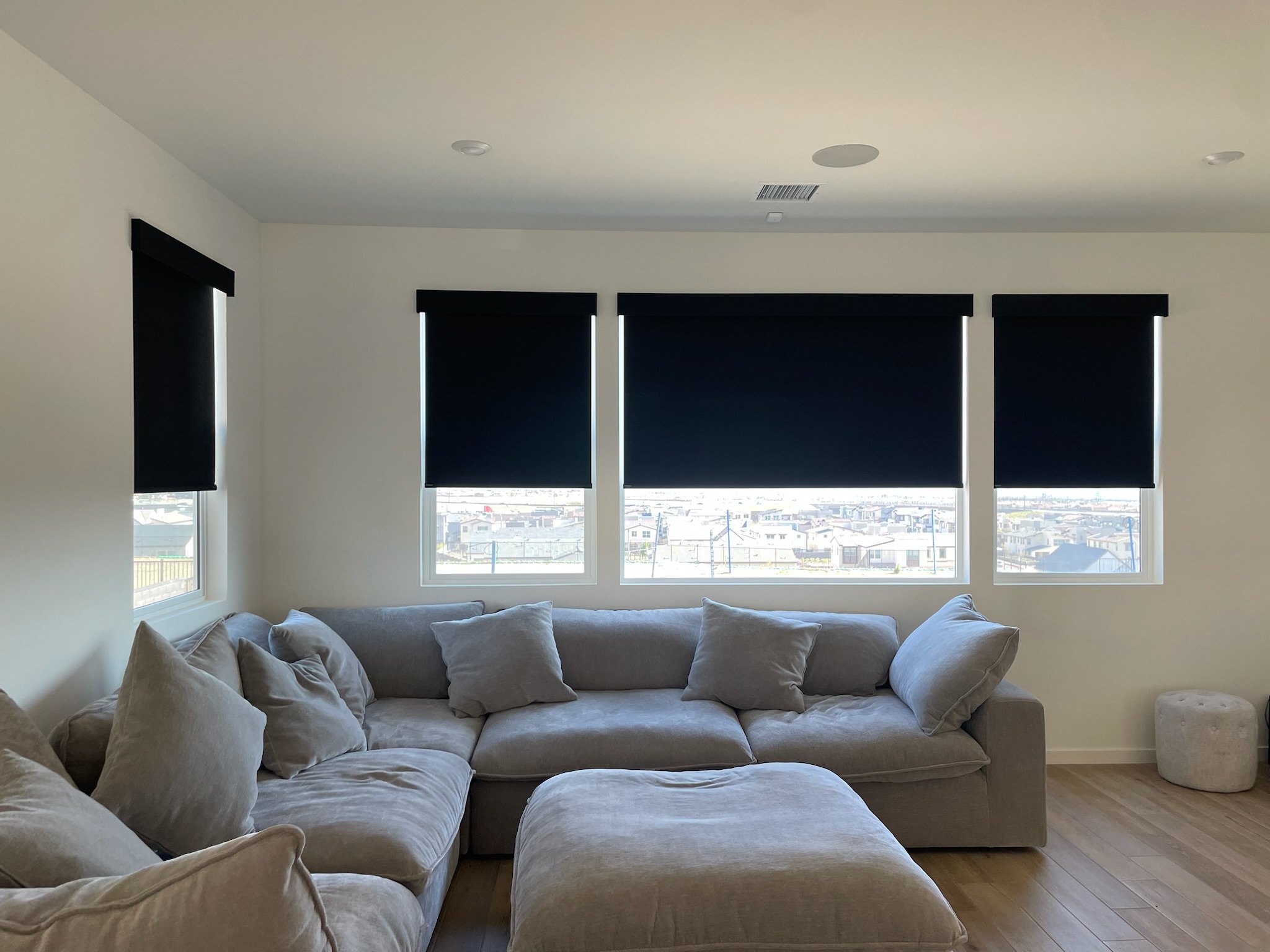 Valley Window Fashion's Black roller shades installed in a modern living room, providing light control and privacy with a clean, minimal design