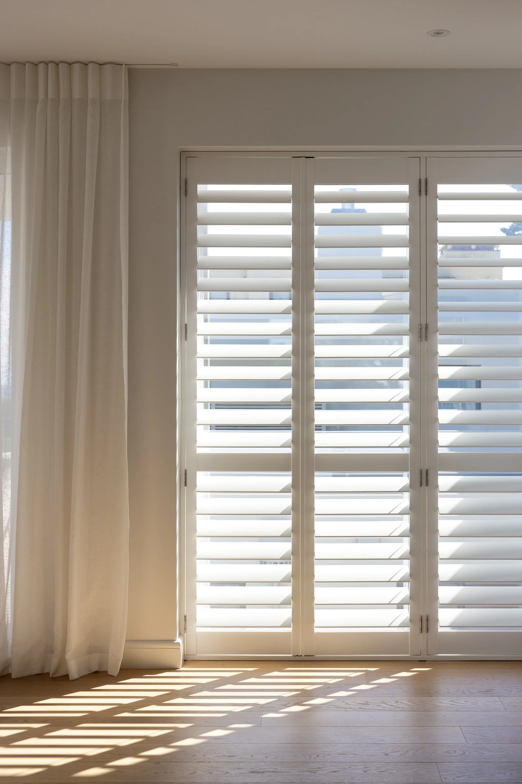 Home interior with sunlight filtered through shutters, Tauranga