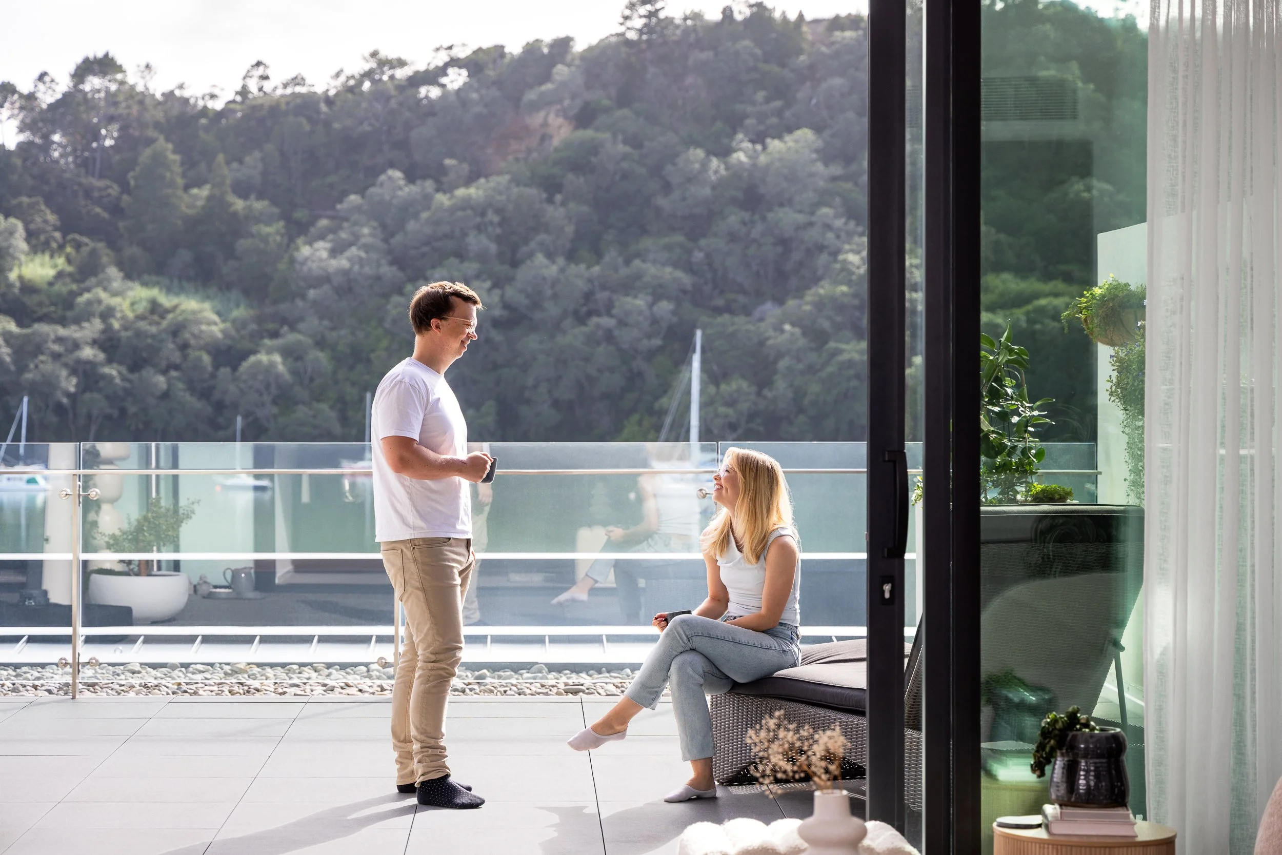 Couple on apartment balcony with bay views, photographed for Willis Bond