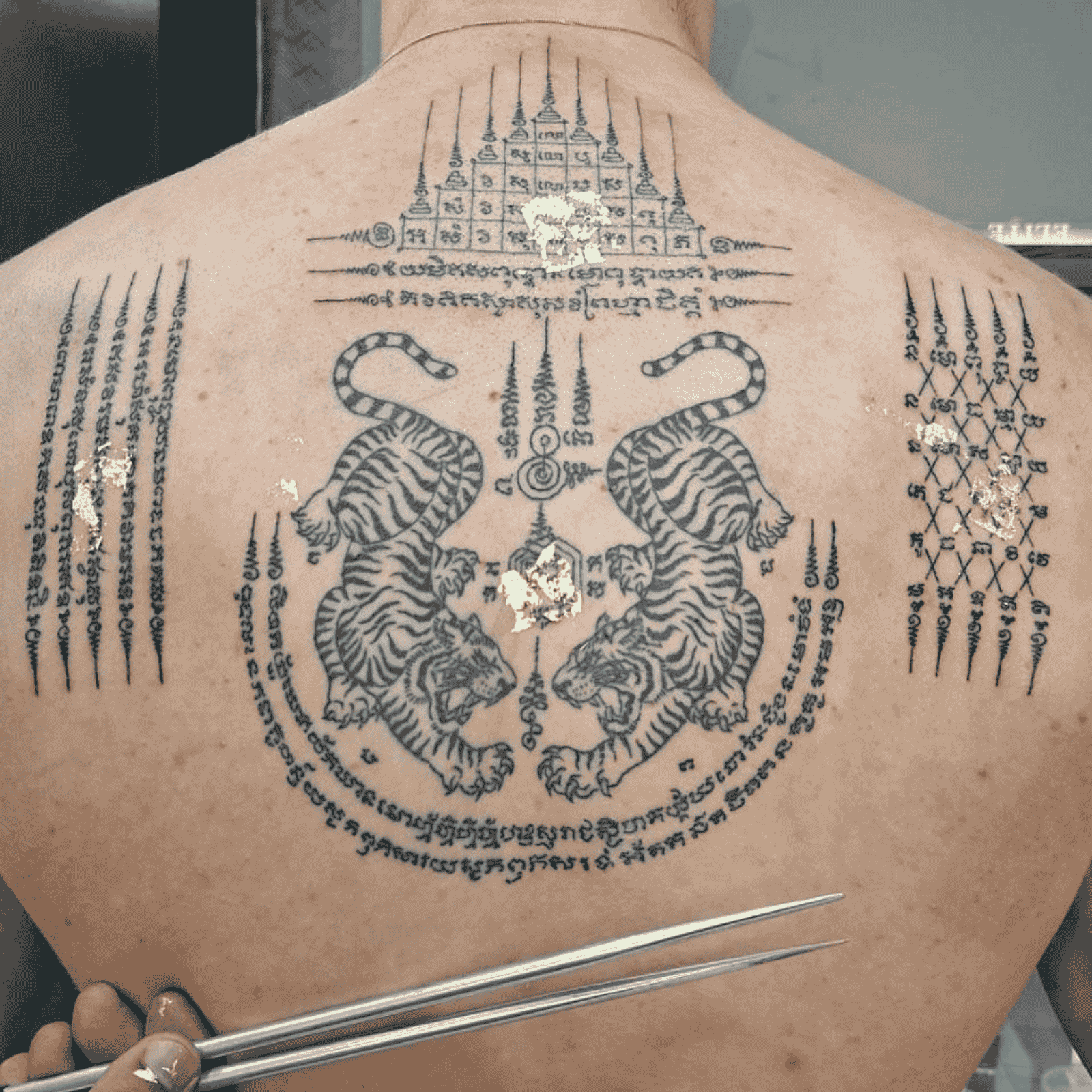 A man with a full back bamboo sak yant piece