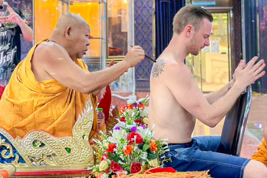 Monk performing a blessing on a pied tidt also known as eight directions tattoo