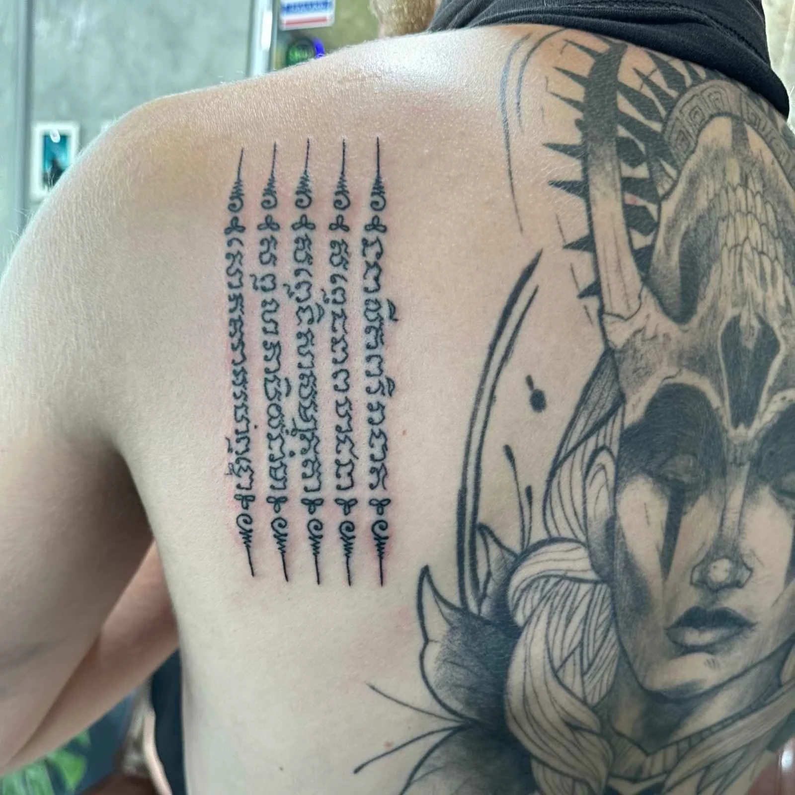 five lines tattoo on a mans left shoulder