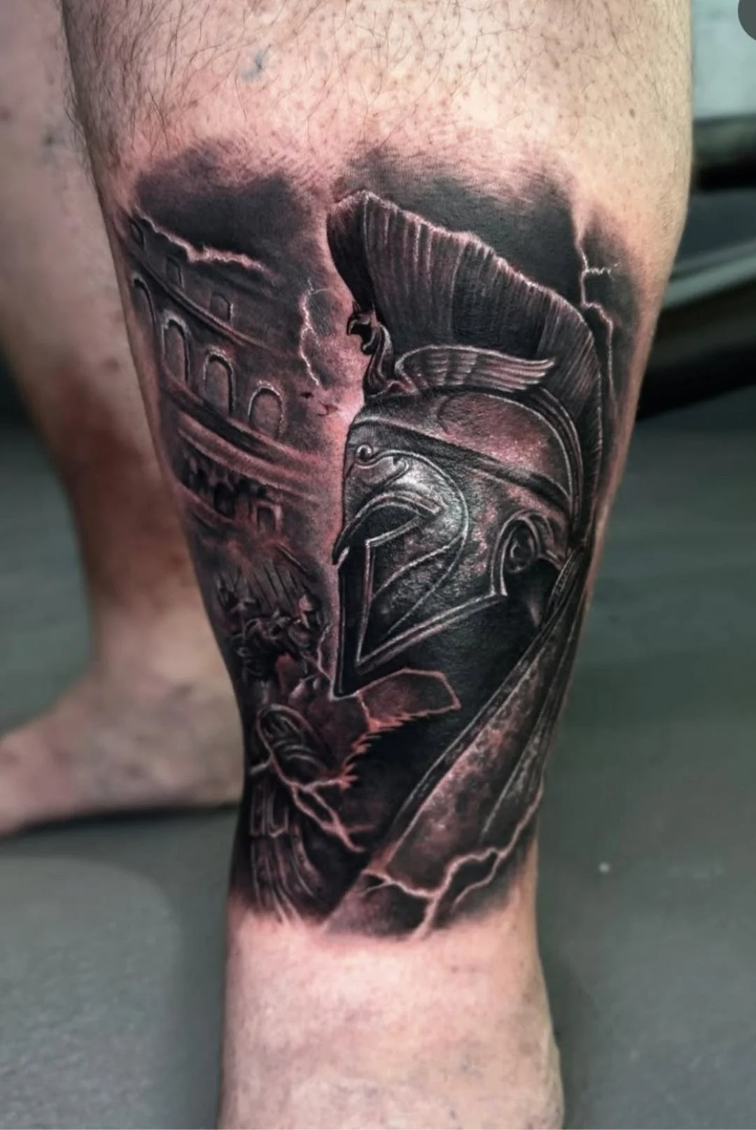 A man with a black work tattoo of a spartan warrior