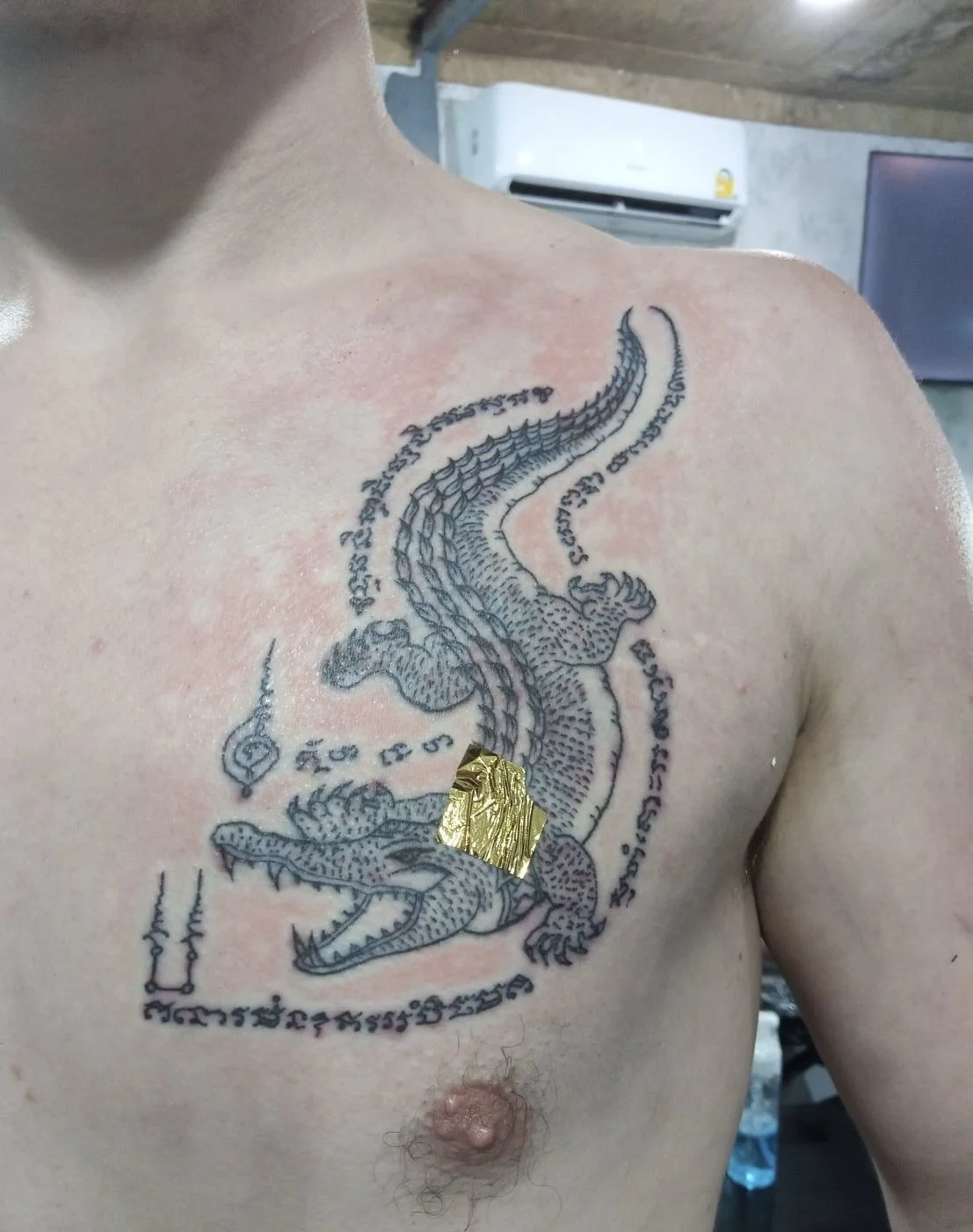 Crocodile Sak Yant on the chest area performed at fighters ink