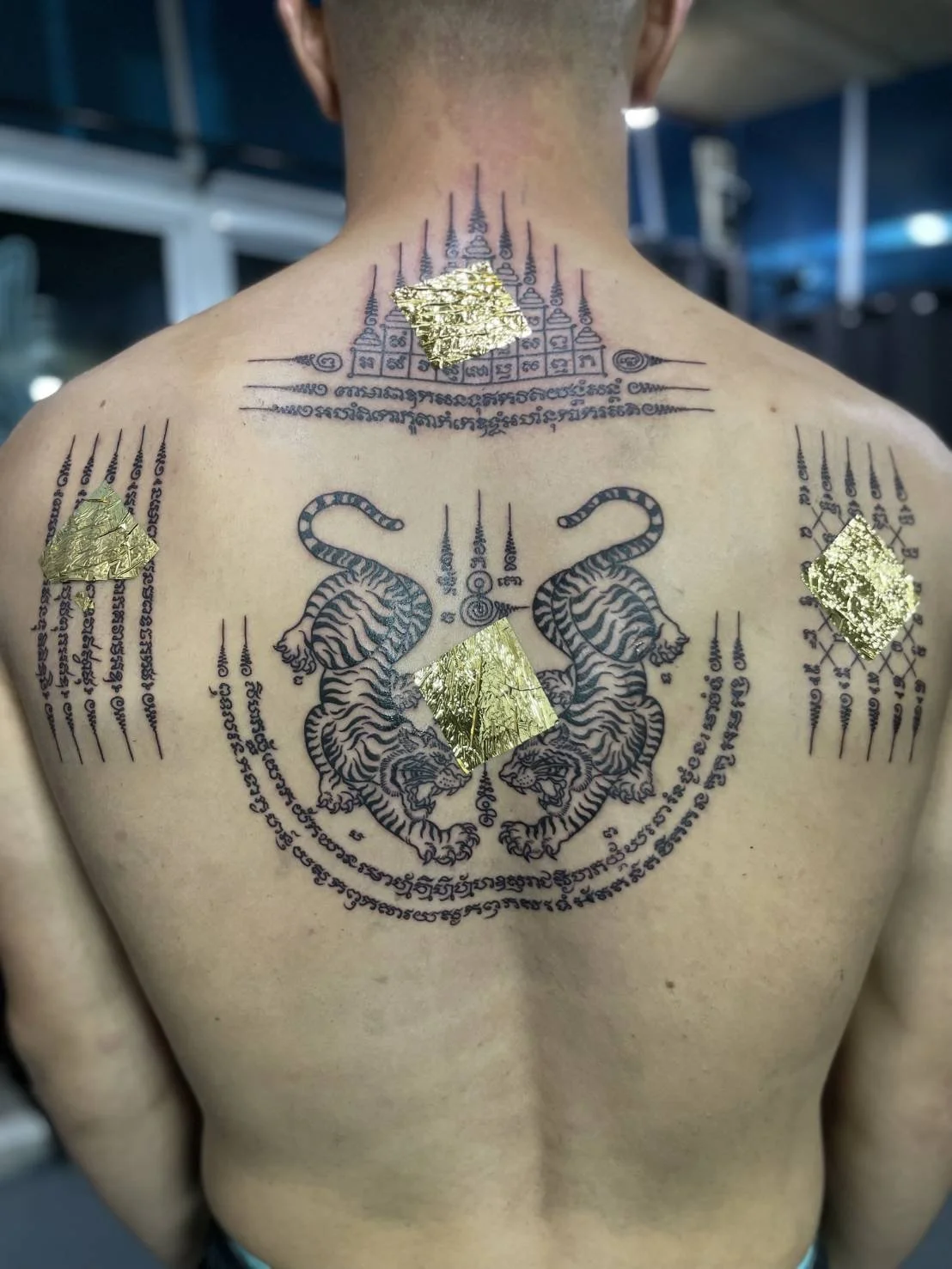 A full back of sak yant tattoos made by bamboo tattoo method