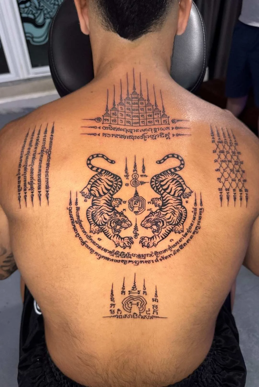 Full back modern machine Sak Yant Phuket featuring twin tigers and sacred yant designs
