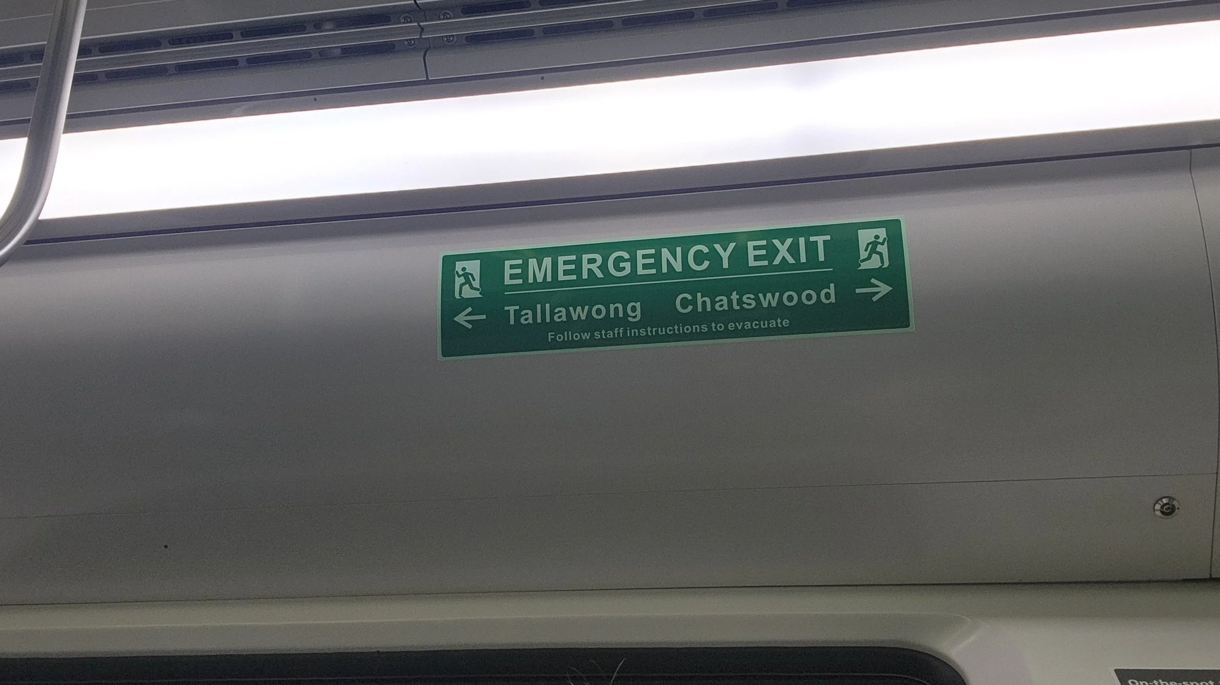A Metro emergency exit sign showing Chatswood to the right and Tallawong to the left