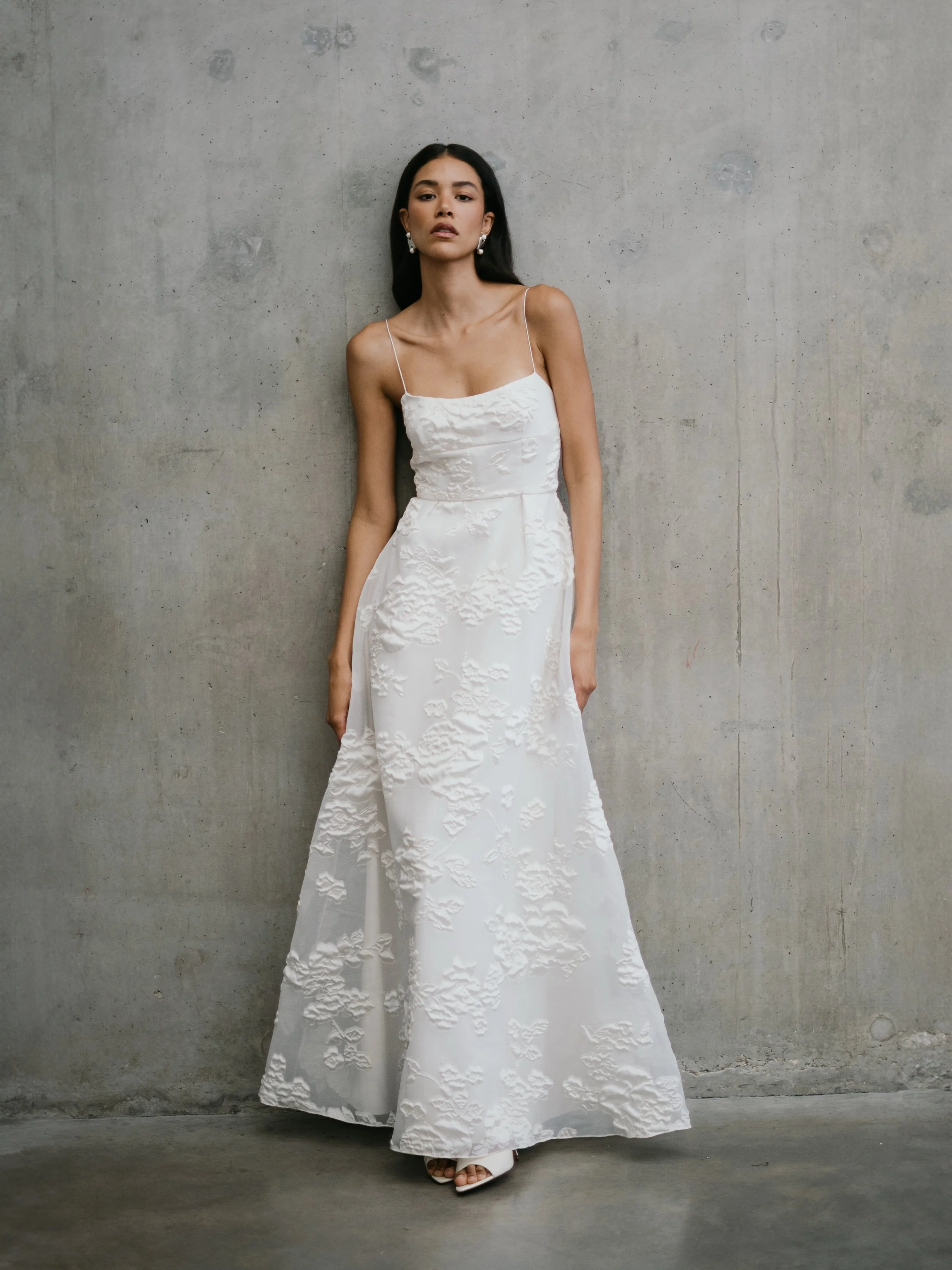 The LISIANTHUS slip gown. An A-line skirt and sculpted bodice suspended from delicate silk shoestring straps. 
Crafted from textural organza jacquard. A bridal gown that fuses modernity, romanticism and minimalism. 
Available exclusively at our UK St
