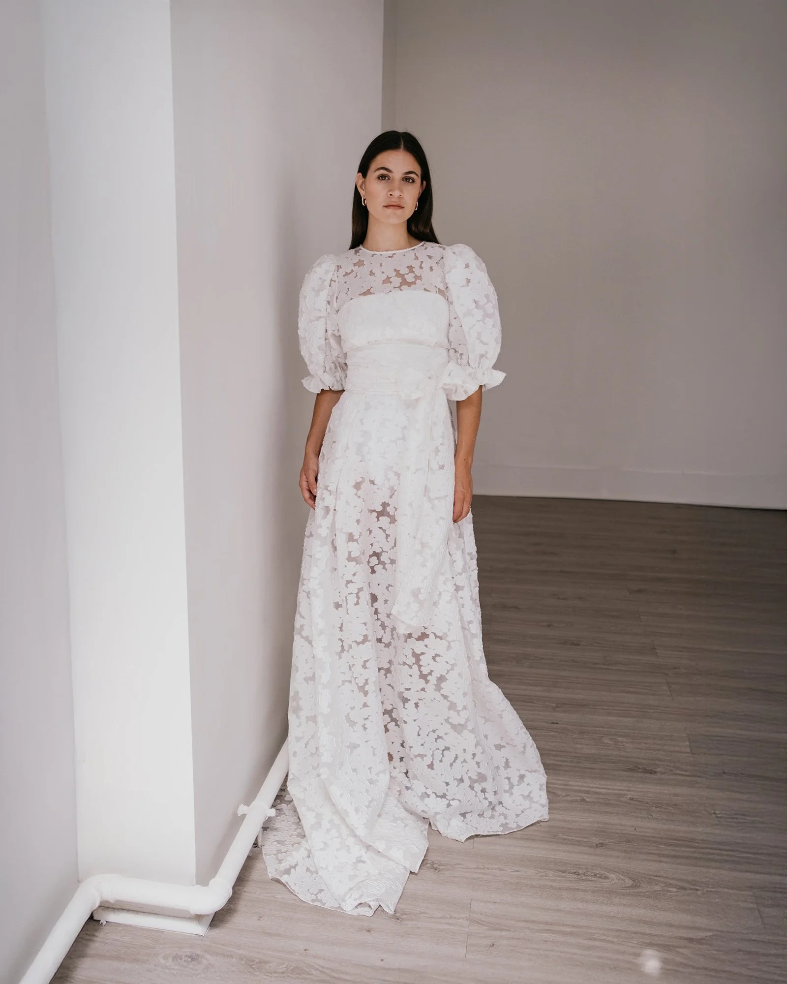 A woman wearing a modern textured bridal skirt with puff sleeve top by British bridal designer Unbridled studio.