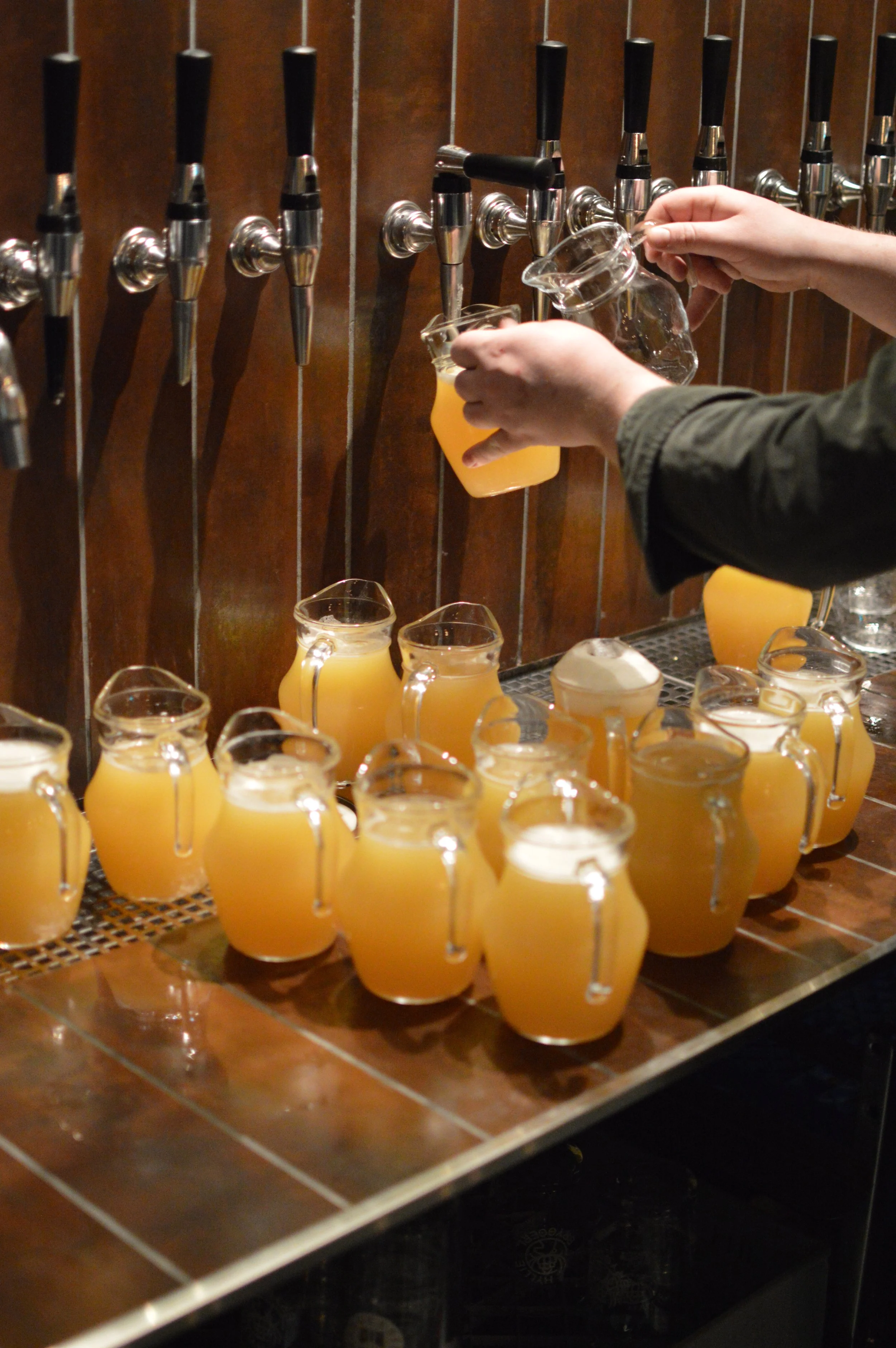 Ett gäng kannor som fylls med humlig Hyllie-öl